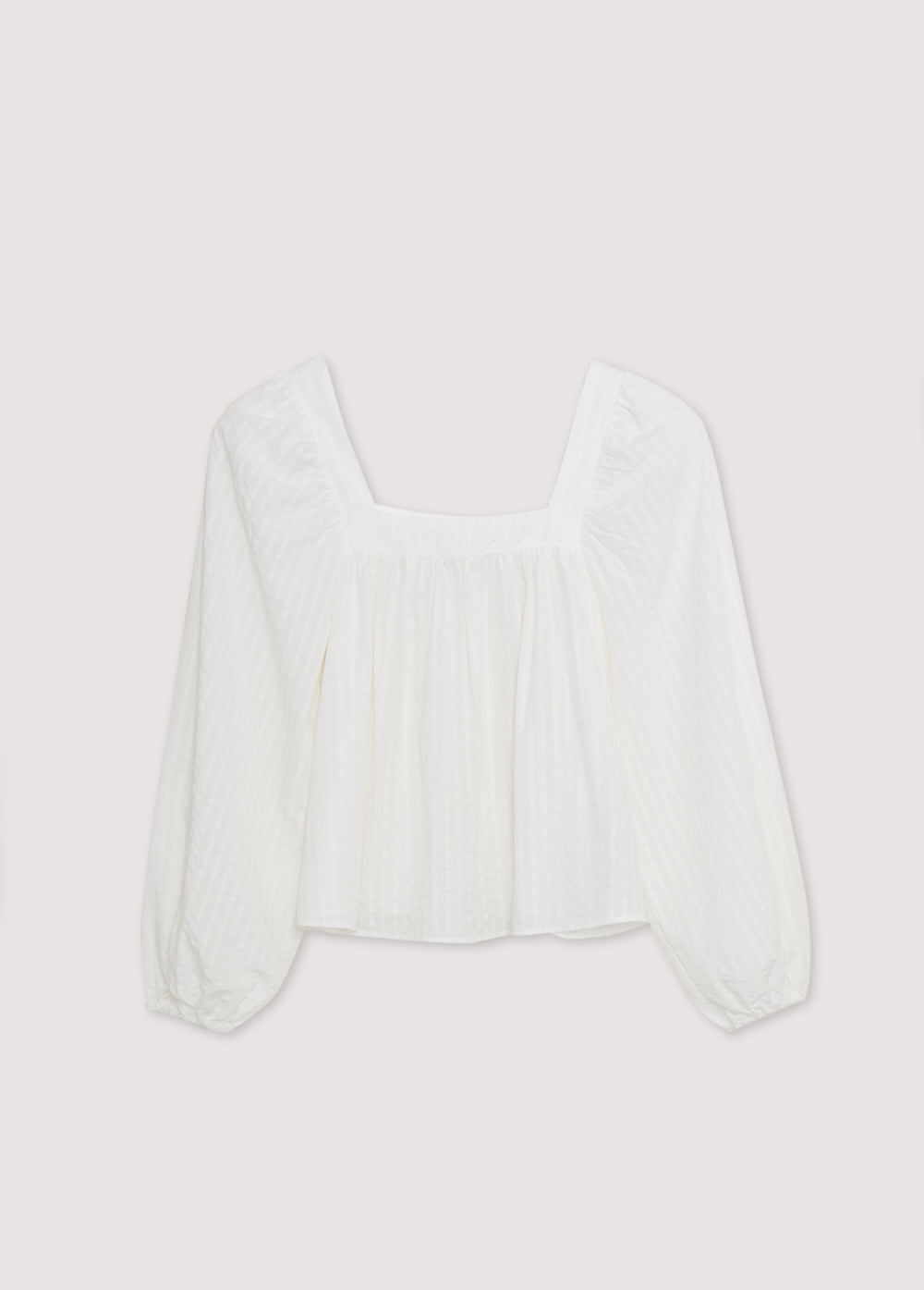 Blouse in crisp white is crafted from 100% Tencel striped fabric, offering a light and breathable feel. The square neckline adds a contemporary touch, while the gathered details create a flattering volume.