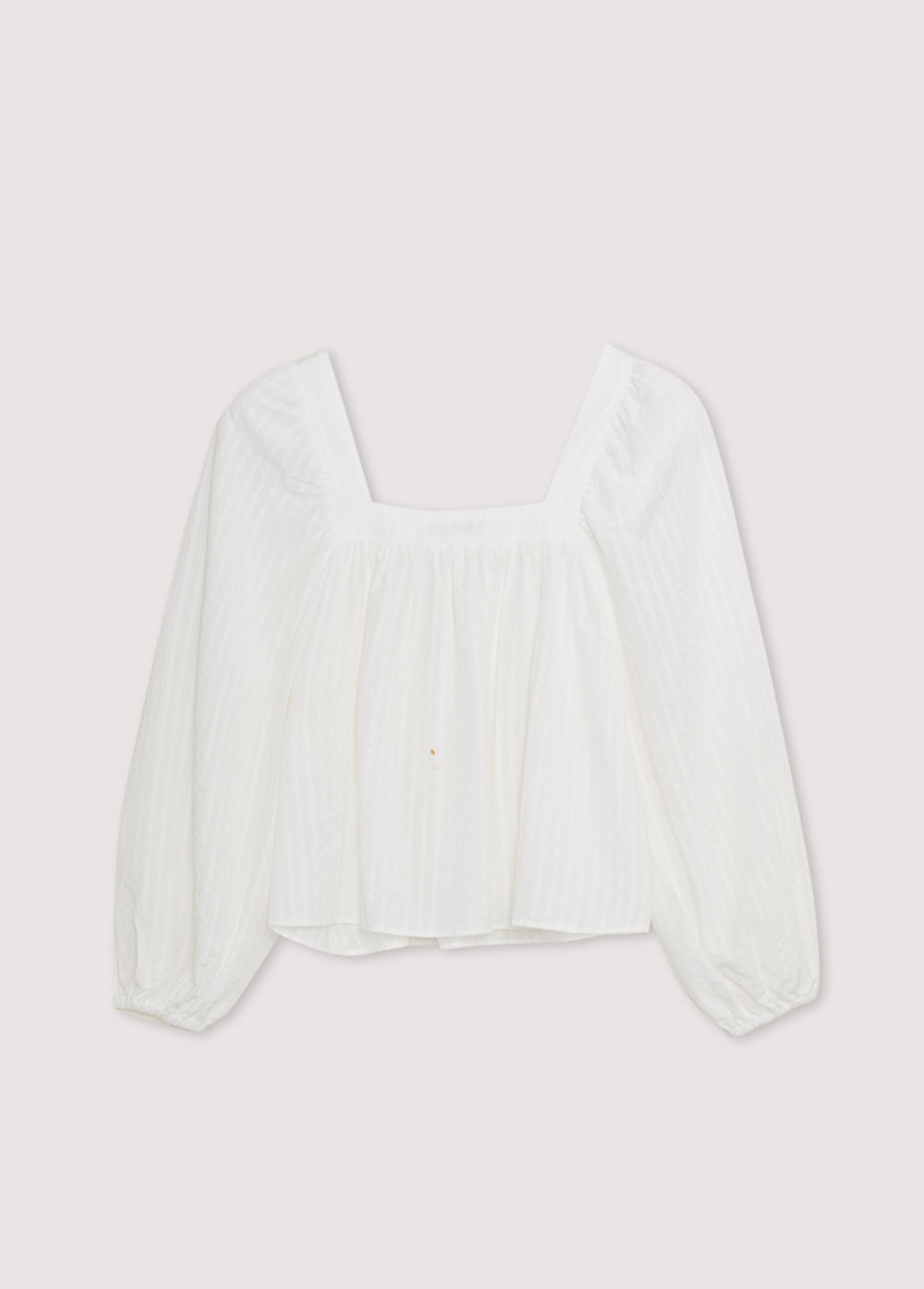 Blouse in crisp white is crafted from 100% Tencel striped fabric, offering a light and breathable feel. The square neckline adds a contemporary touch, while the gathered details create a flattering volume.