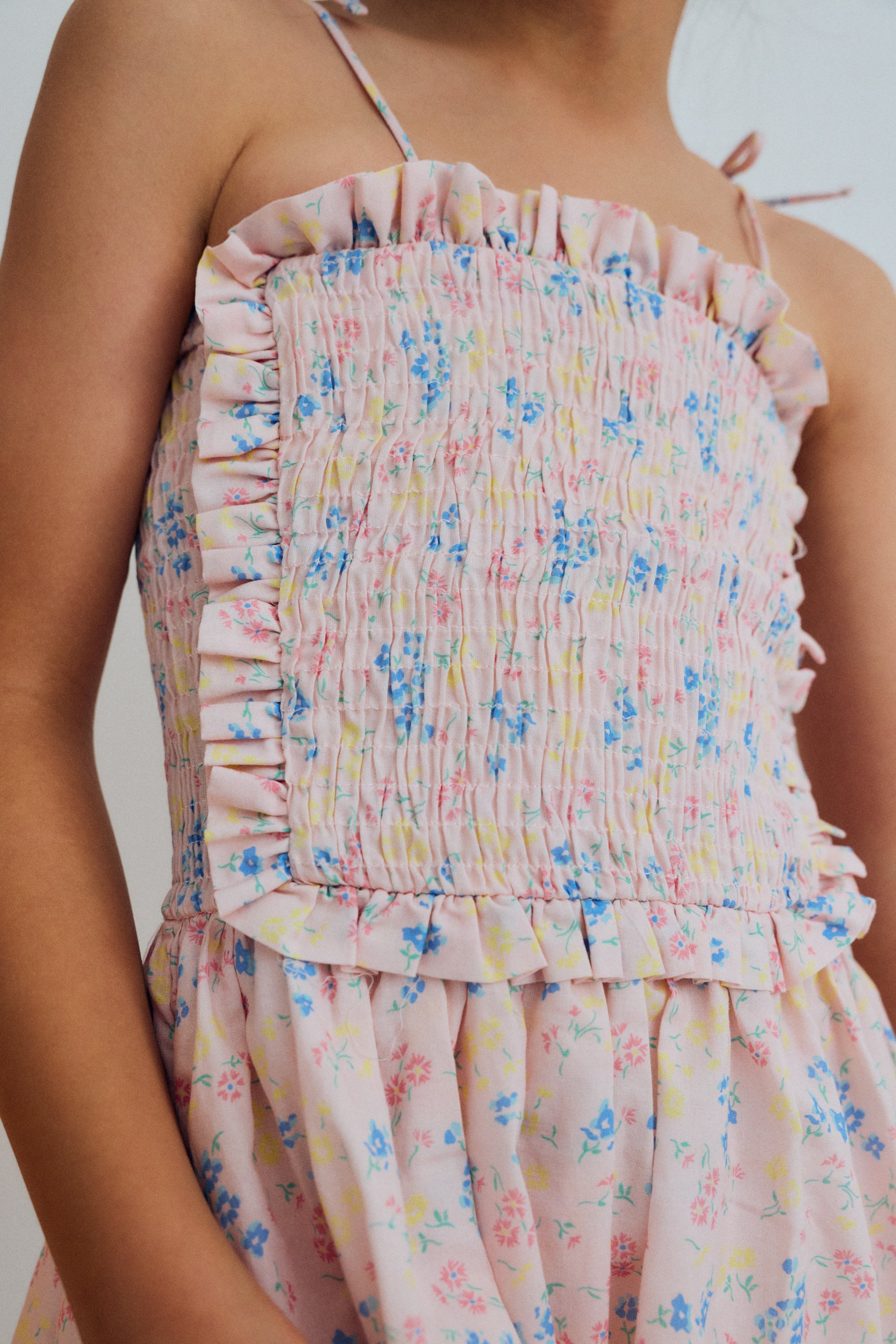 Dress in organic cotton with a lovely floral print, featuring a smocked bodice with delicate ruffle trim for a comfortable and flattering fit