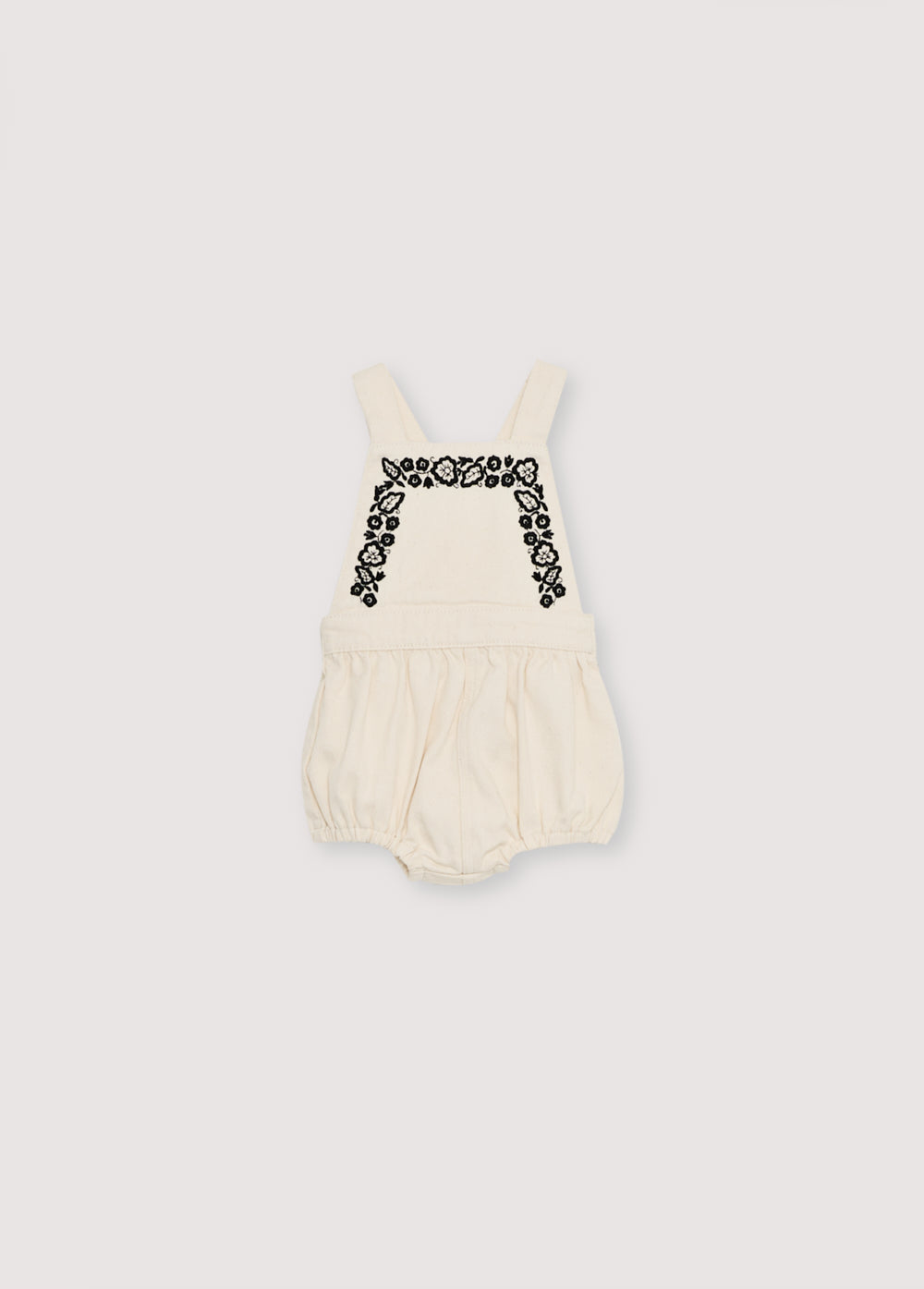 Denim romper with adjustable straps at the back and contrast embroidery detail on the front.