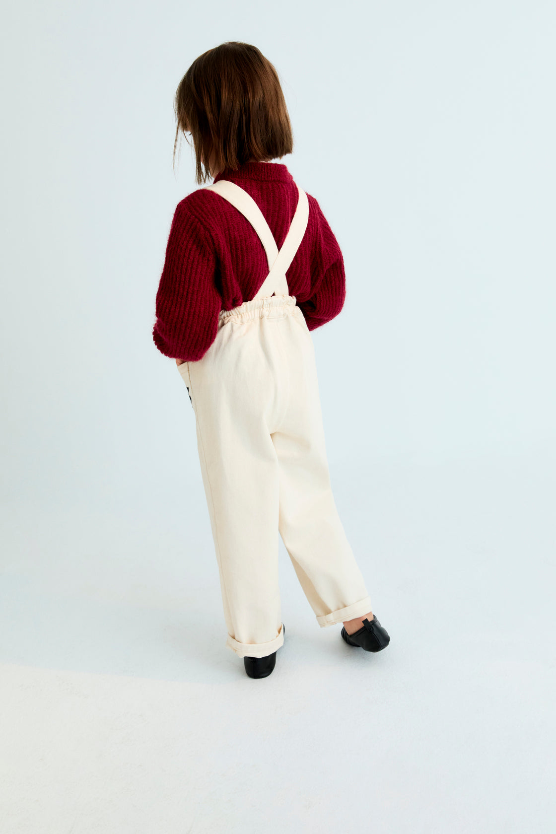 Denim overall with contrast embroidery details on the upper front and two patch pockets in the front. It features an elastic waistband at the back and adjustable straps at the back.