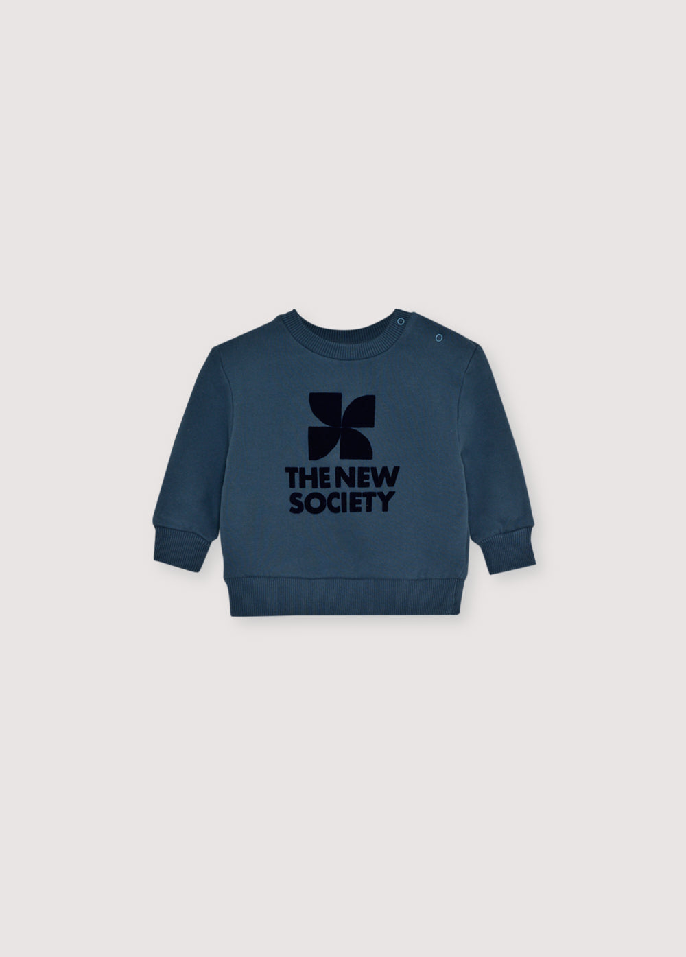 Our classic sweatshirt with a contrasting flock print on the front. It features a shoulder opening with tone-on-tone snaps.