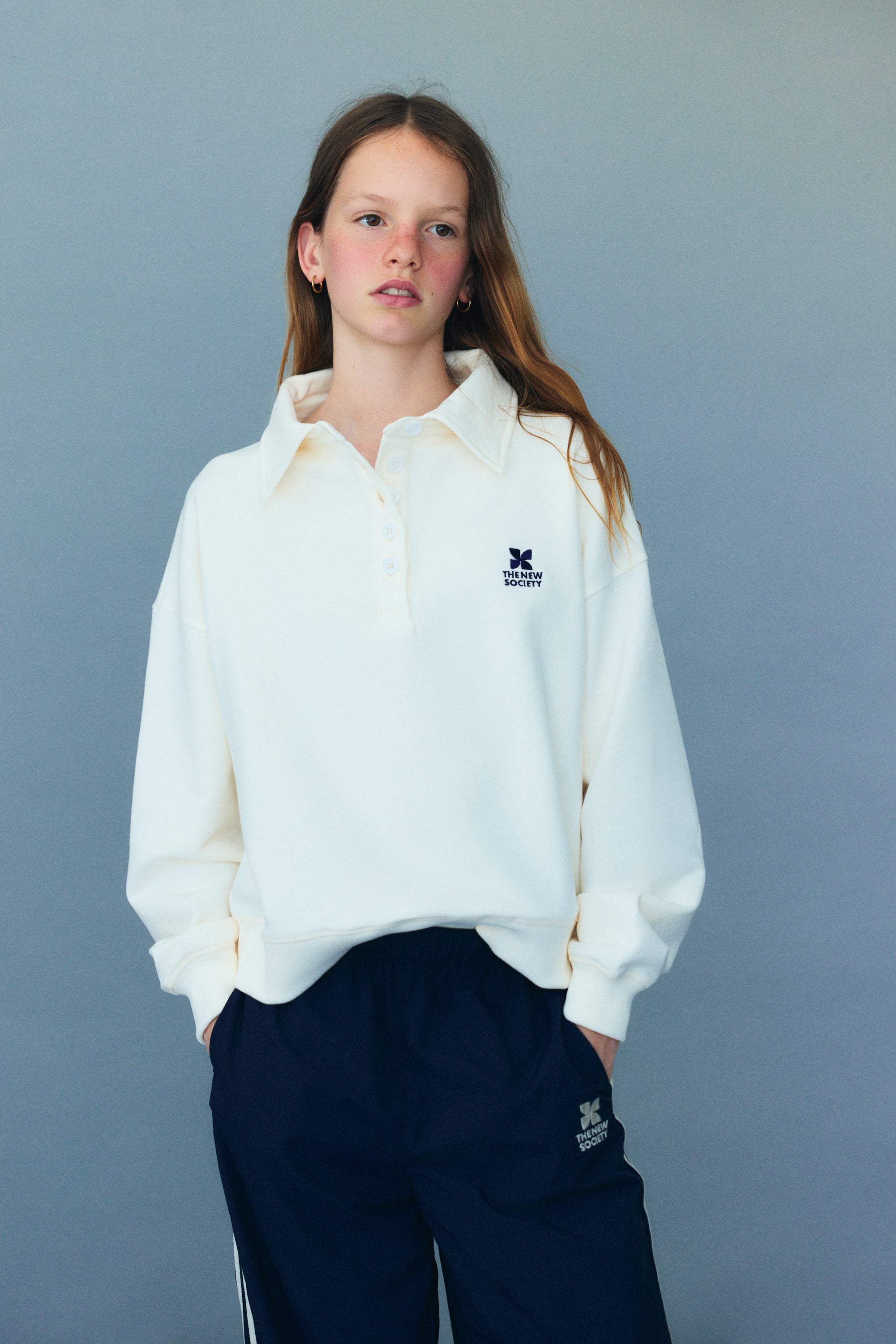 Soft cotton fleece polo featuring ribbed cuffs and hem, a tonal buttoned opening at the neck, and branded embroidery on the chest