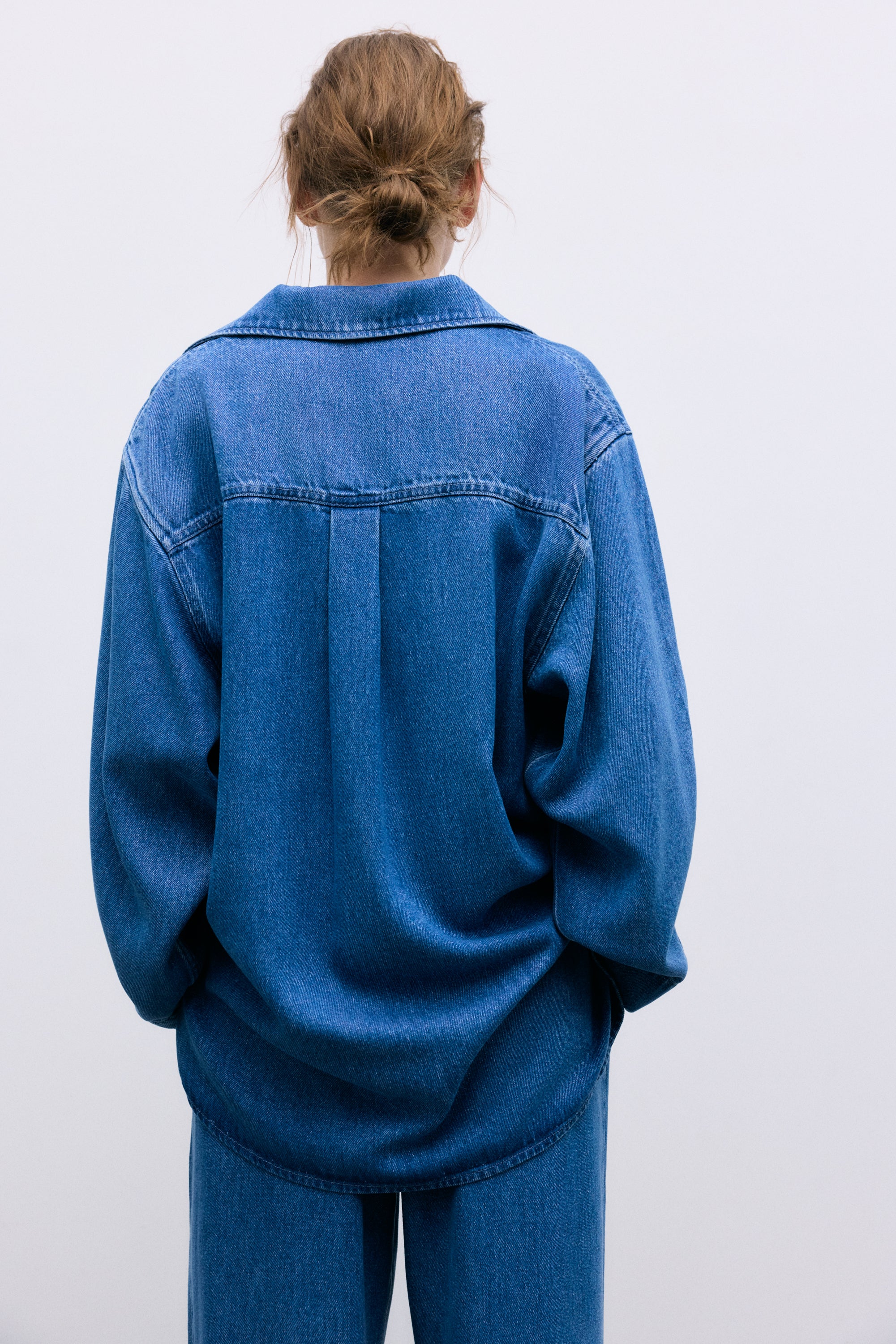 Crafted from 100% Tencel for a soft, lightweight feel, this polo-style shirt features an oversized fit and a front opening with hidden buttons.