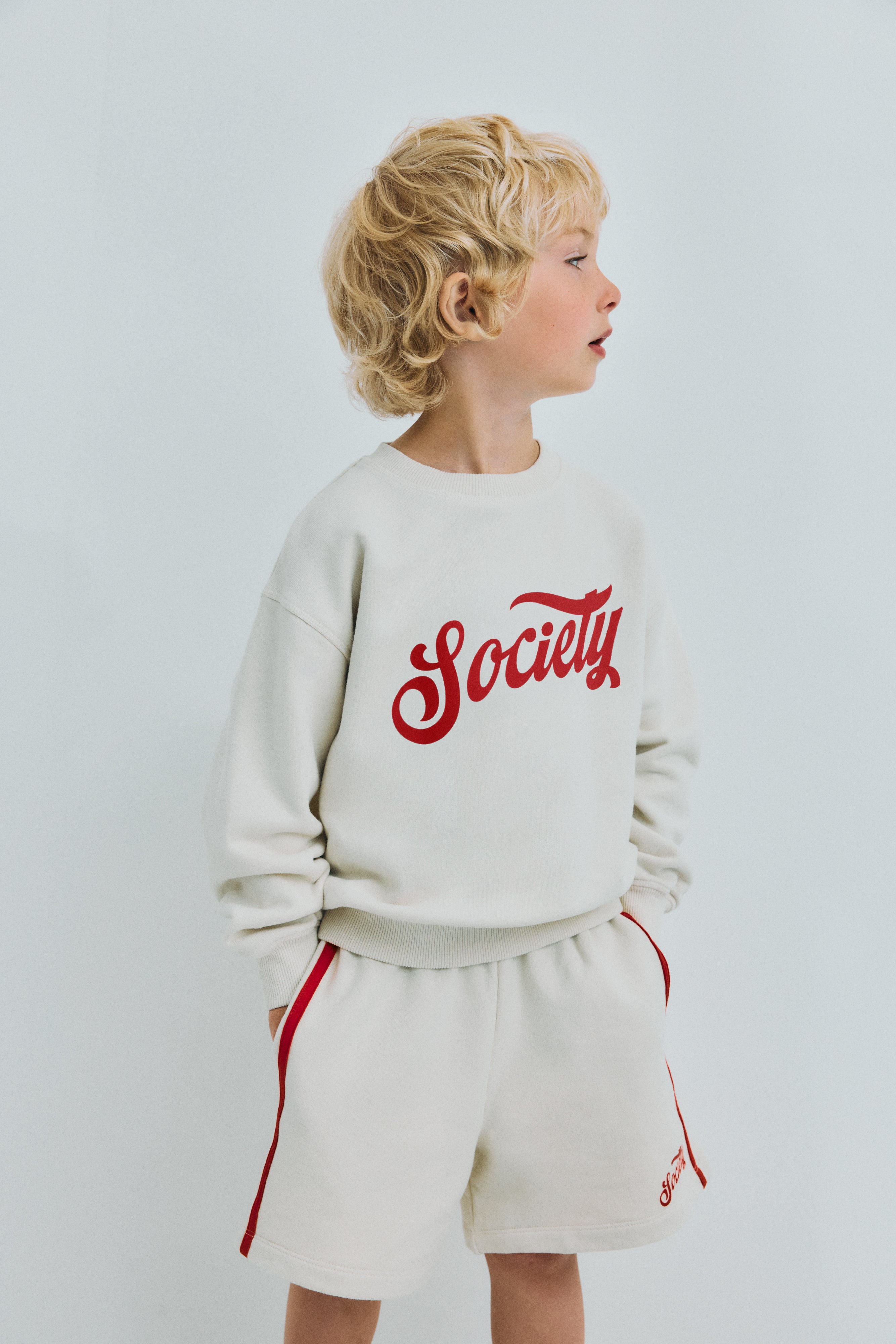 Soft cotton terry bermuda shorts featuring an elastic waistband, side pockets, double contrasting side stripes, and a brand print on the hem for a sporty, stylish finish.