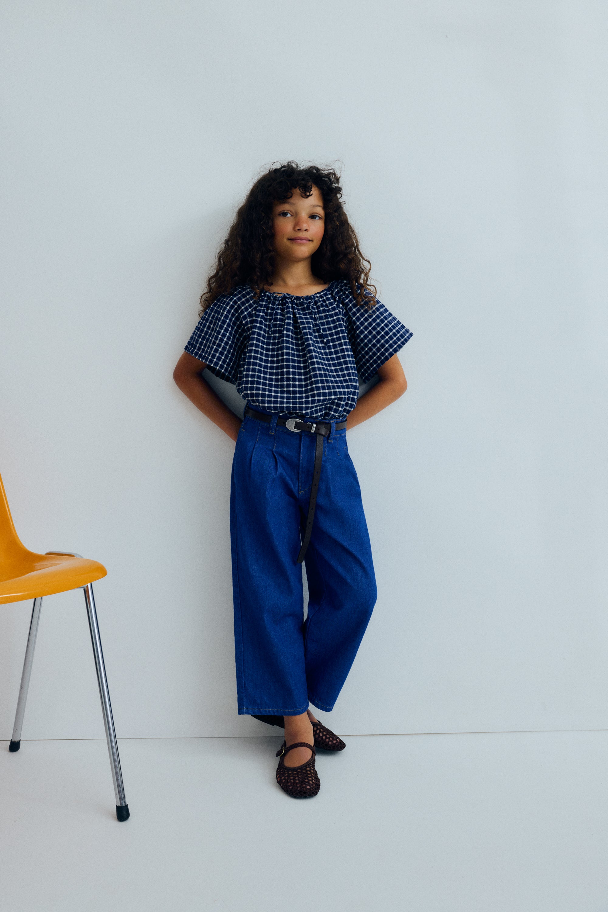 Wide leg denim trousers with front pleats that enhance the relaxed silhouette.