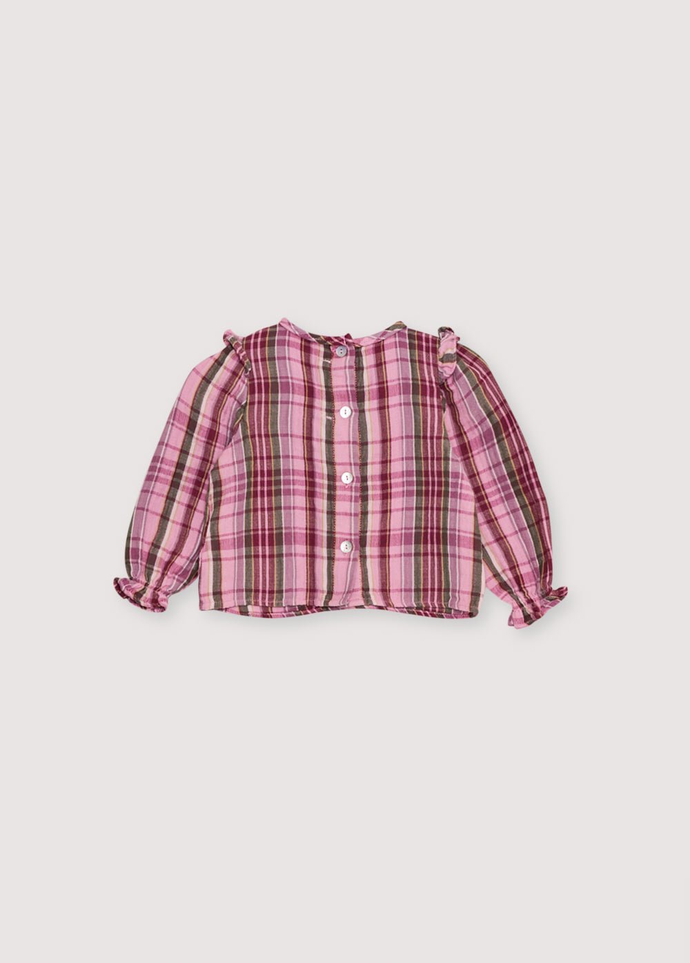 Blouse bébé en double gaze à carreaux avec empiècement smocké et détail volant. Il présente une ouverture au dos avec une patte et des boutons. Parfait à associer avec le bloomer assorti.