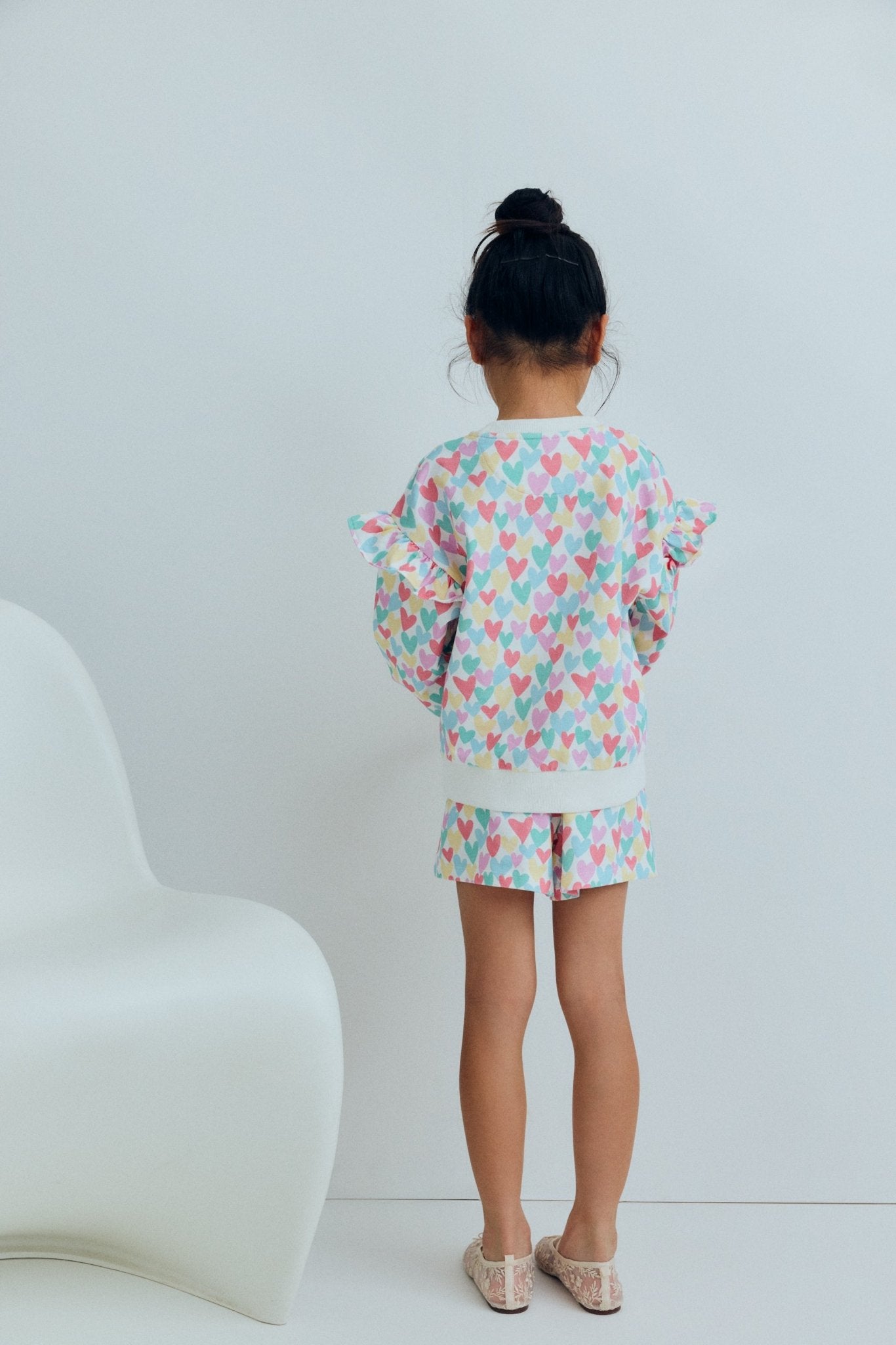 Sweat-shirt pour enfants avec un imprimé ludique de cœurs multicolores qui ajoute une touche amusante et joyeuse aux tenues de tous les jours