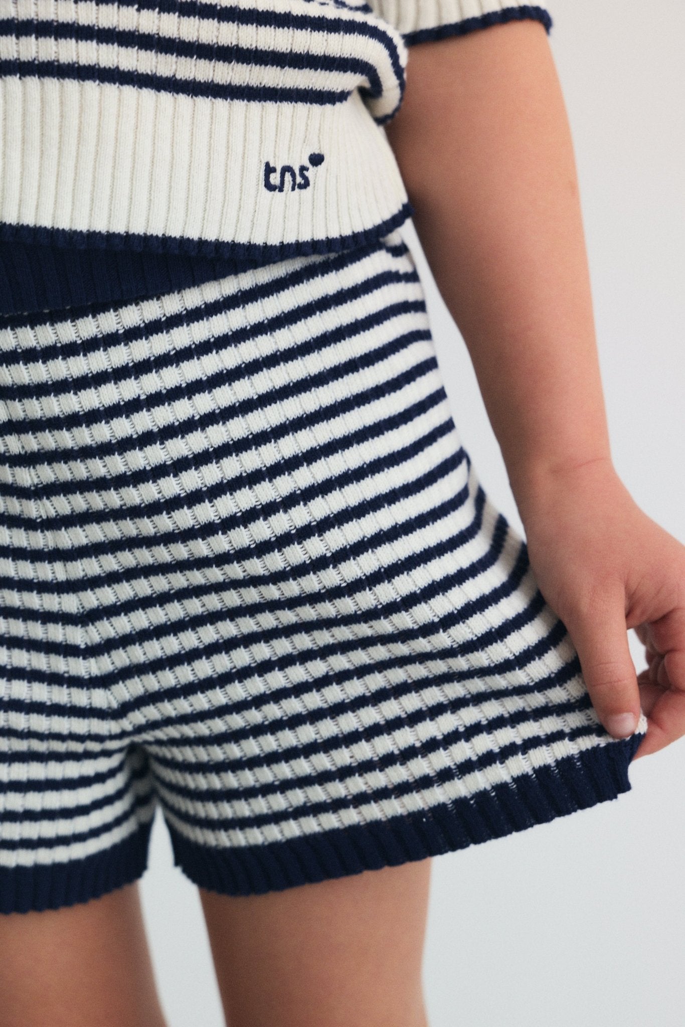 클래식한 세일러 스타일 스트라이프와 골지 부분에 은은한 브랜드 자수가 있는 가벼운 니트 폴로입니다.