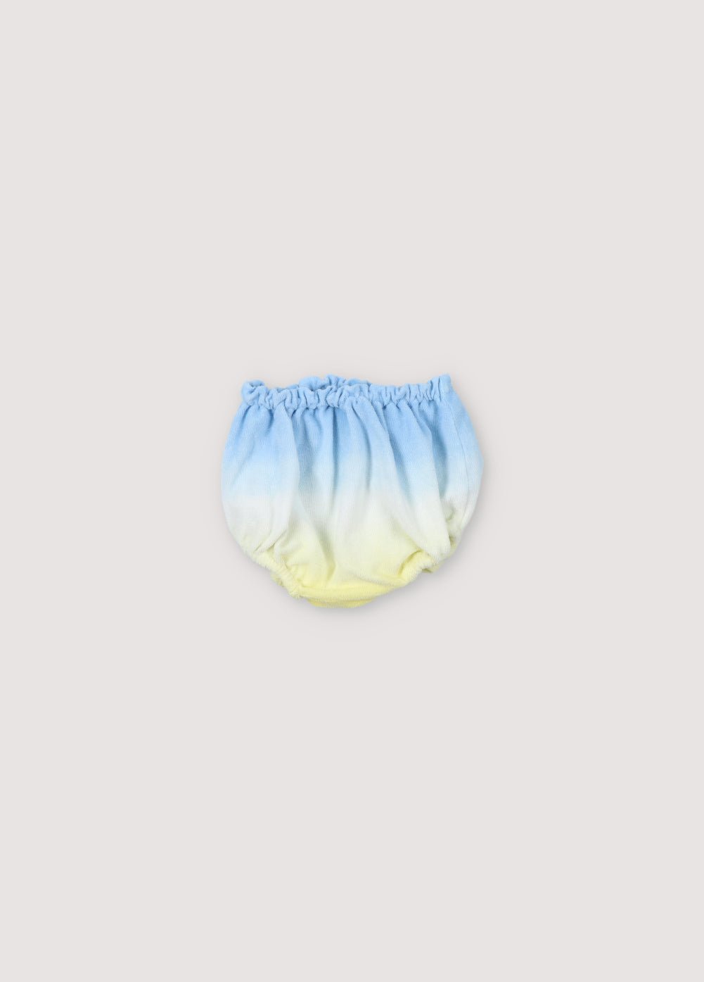 Bloomer pour bébé en tissu éponge avec effet tie-dye et jambes et taille élastiques pour un effet froncé. Parfait à combiner avec le T-shirt assorti de la collection Printemps Été. The New Society.