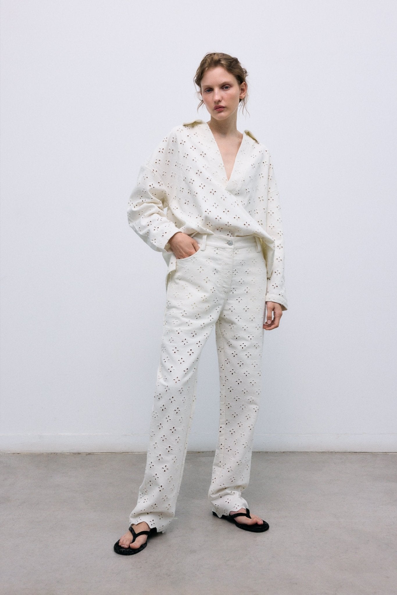 Blusa estilo polo con cuello camisero y abertura frontal, confeccionada con un delicado y especial tejido denim con bordado integral para un acabado texturizado único.