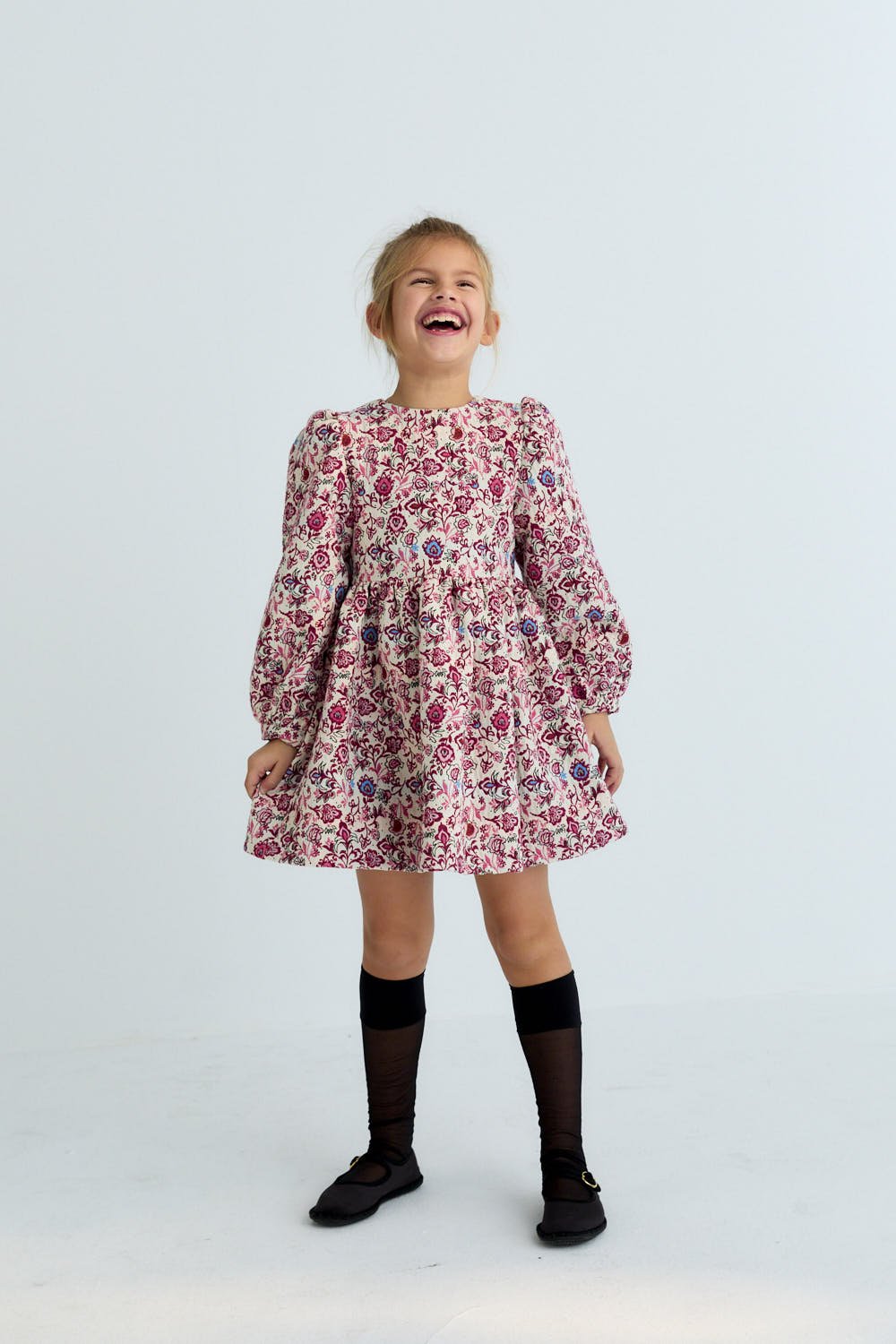 Young girl wearing a floral dress on a white background