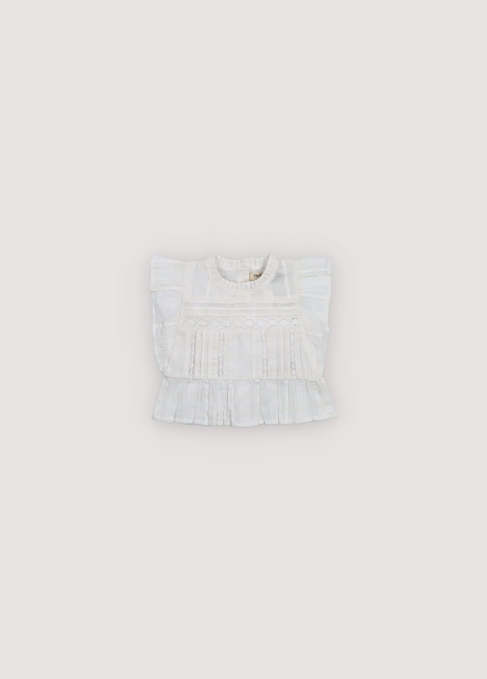 Blouse avec tissu jacquard et détails en dentelle. Il présente des volants sur les manches et une patte de boutonnage au dos avec boutons en nacre. Collection Printemps Été. The New Society.