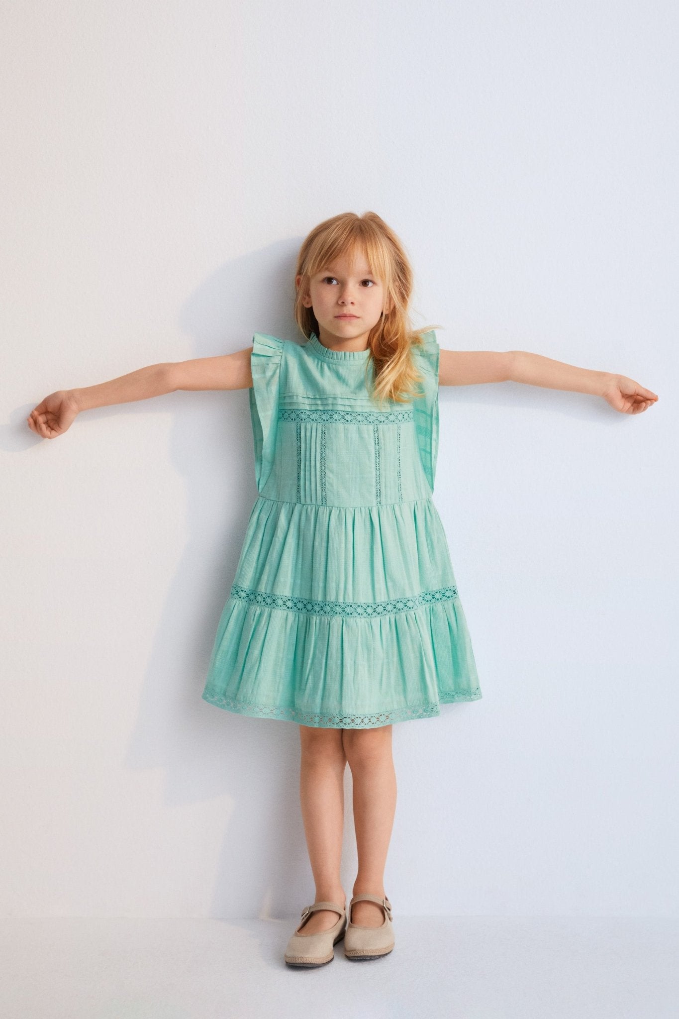 Short dress with jacquard fabric and lace details. It features ruffles on the sleeves and an opening at the back with mother-of-pearl button.