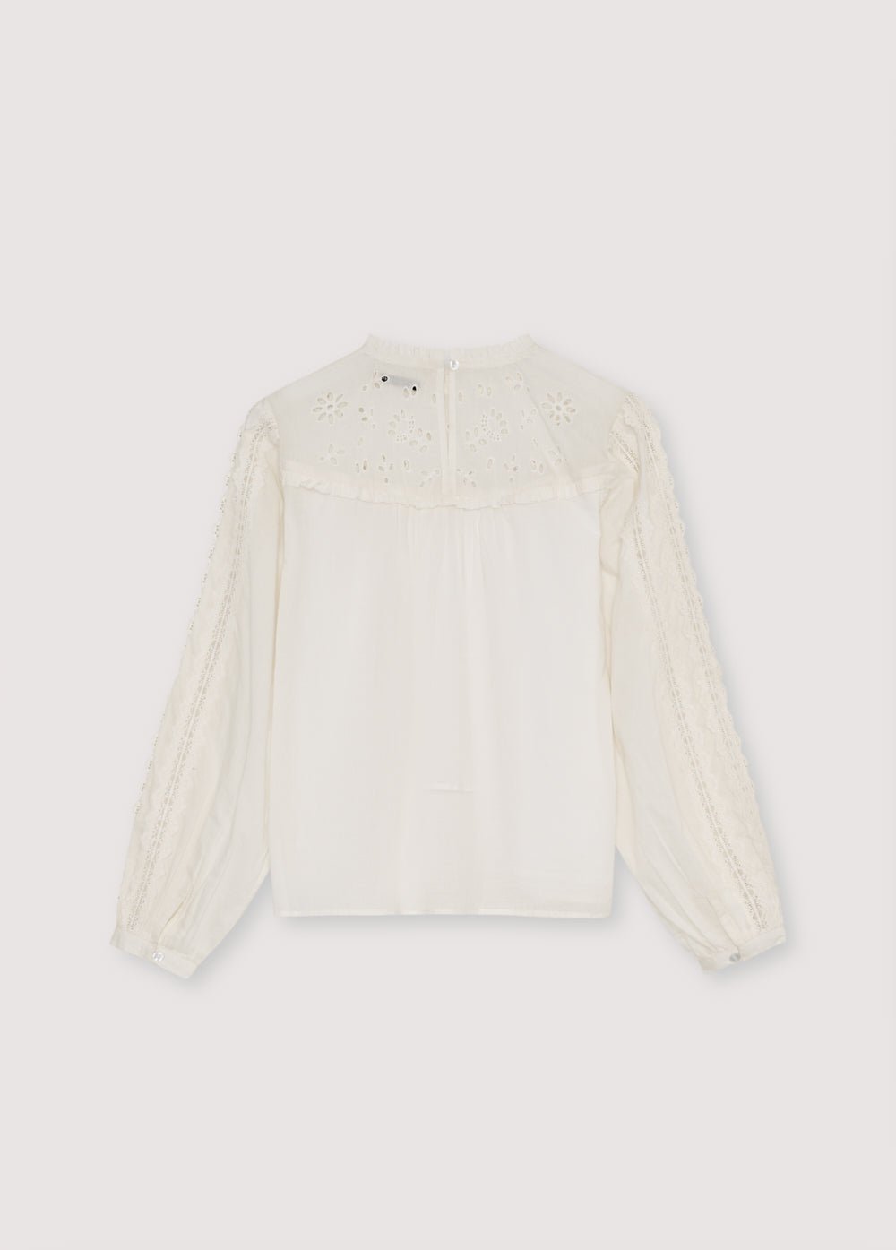 Blouse en batiste avec empiècement et volants brodés, et détails en dentelle sur le corps et les manches. Il présente une ouverture goutte d'eau au dos avec un bouton ton sur ton.