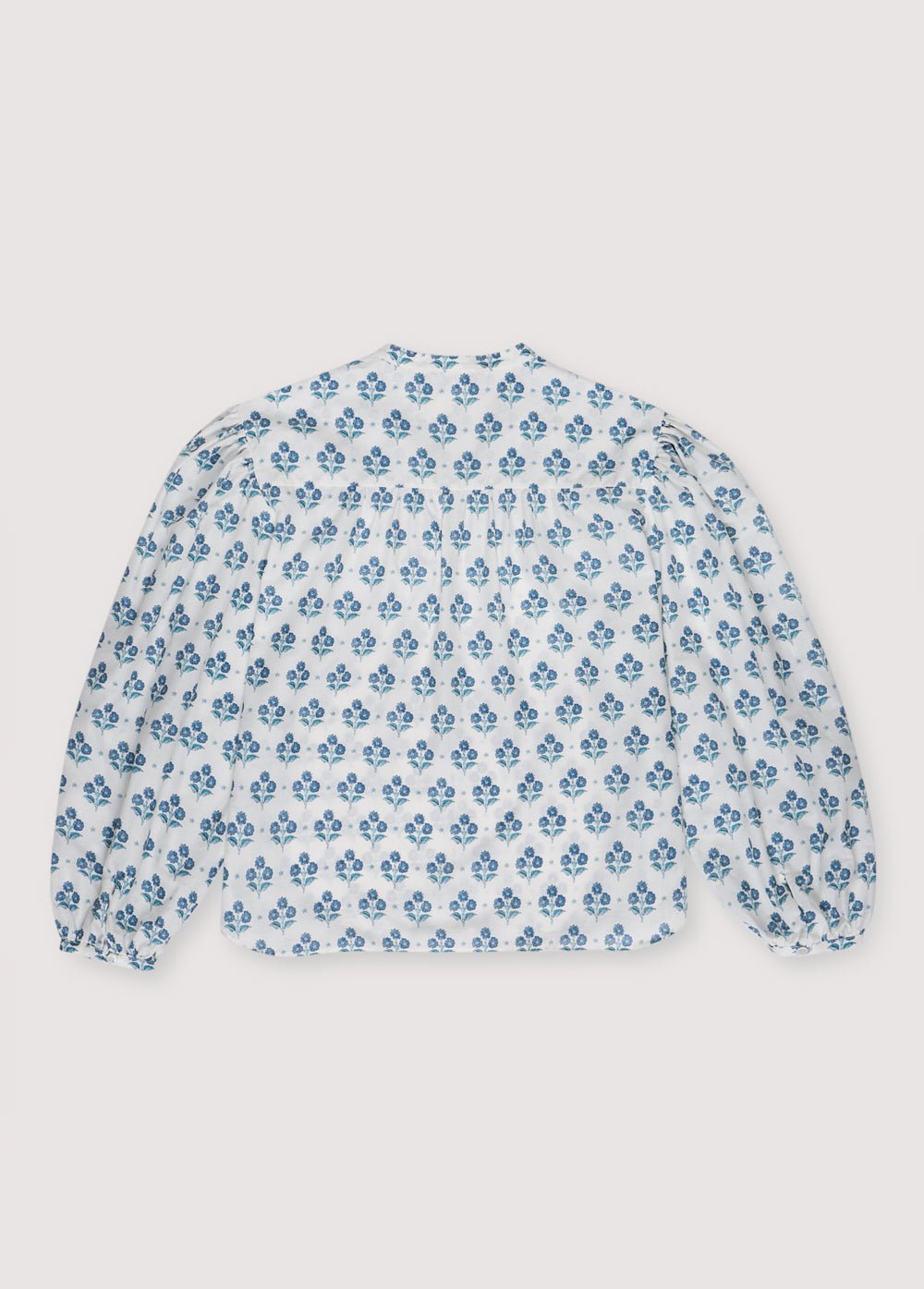 Blusa Mujer Eleni en popelina 100% algodón con nuestro estampado Jacinto. Blusa de manga larga con volante de cuello alto y lazo.