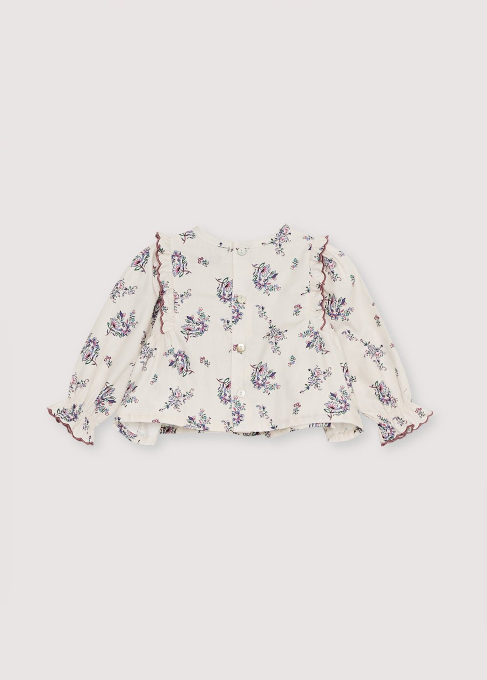 Blouse en flanelle avec un bel imprimé floral et un empiècement devant avec volants. Il présente de délicates finitions de broderie incurvées qui le rendent spécial. Il s'ouvre à l'arrière avec une fermeture à boutons-pression.