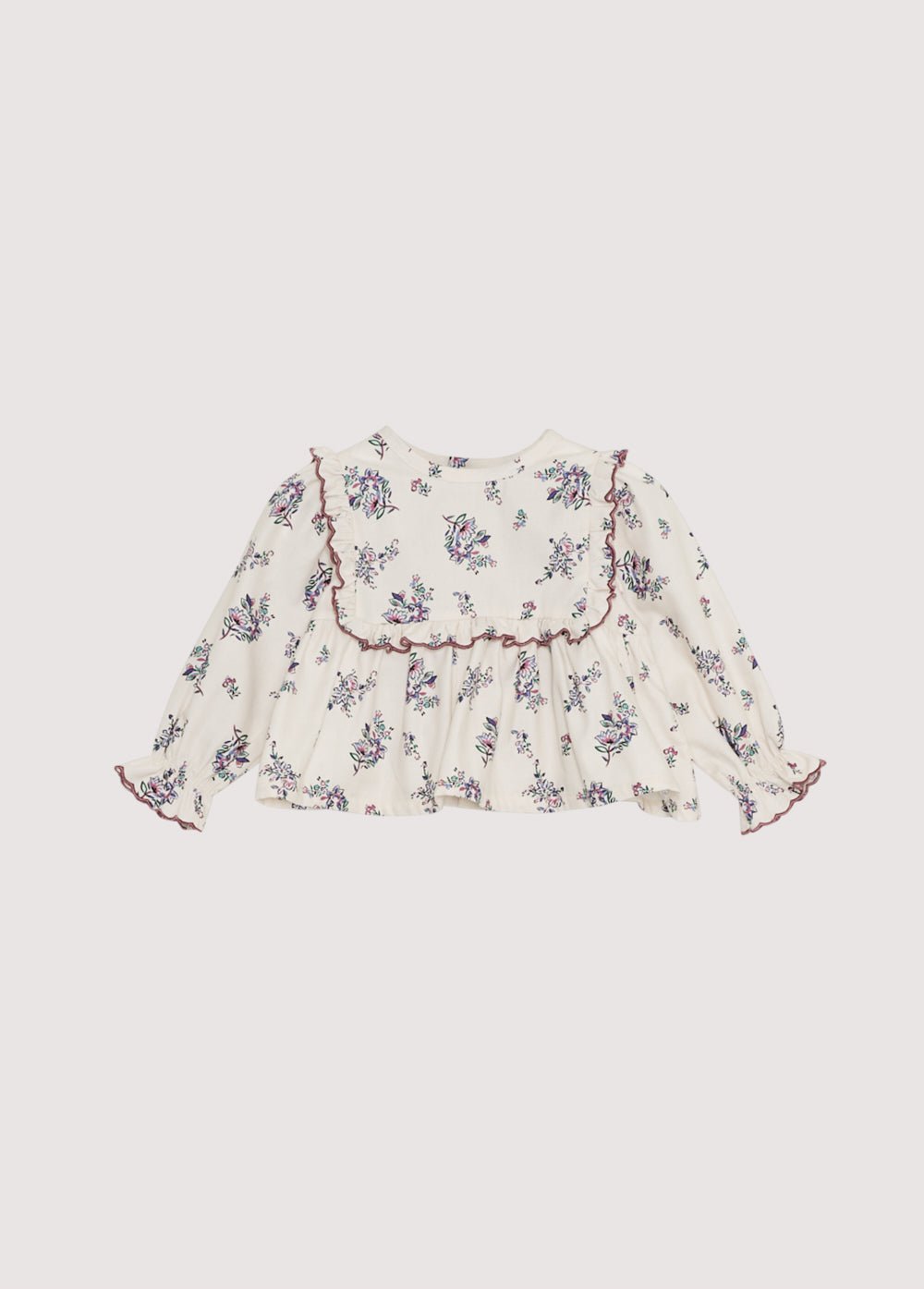 Blouse en flanelle avec un bel imprimé floral et un empiècement devant avec volants. Il présente de délicates finitions de broderie incurvées qui le rendent spécial. Il s'ouvre à l'arrière avec une fermeture à boutons-pression.