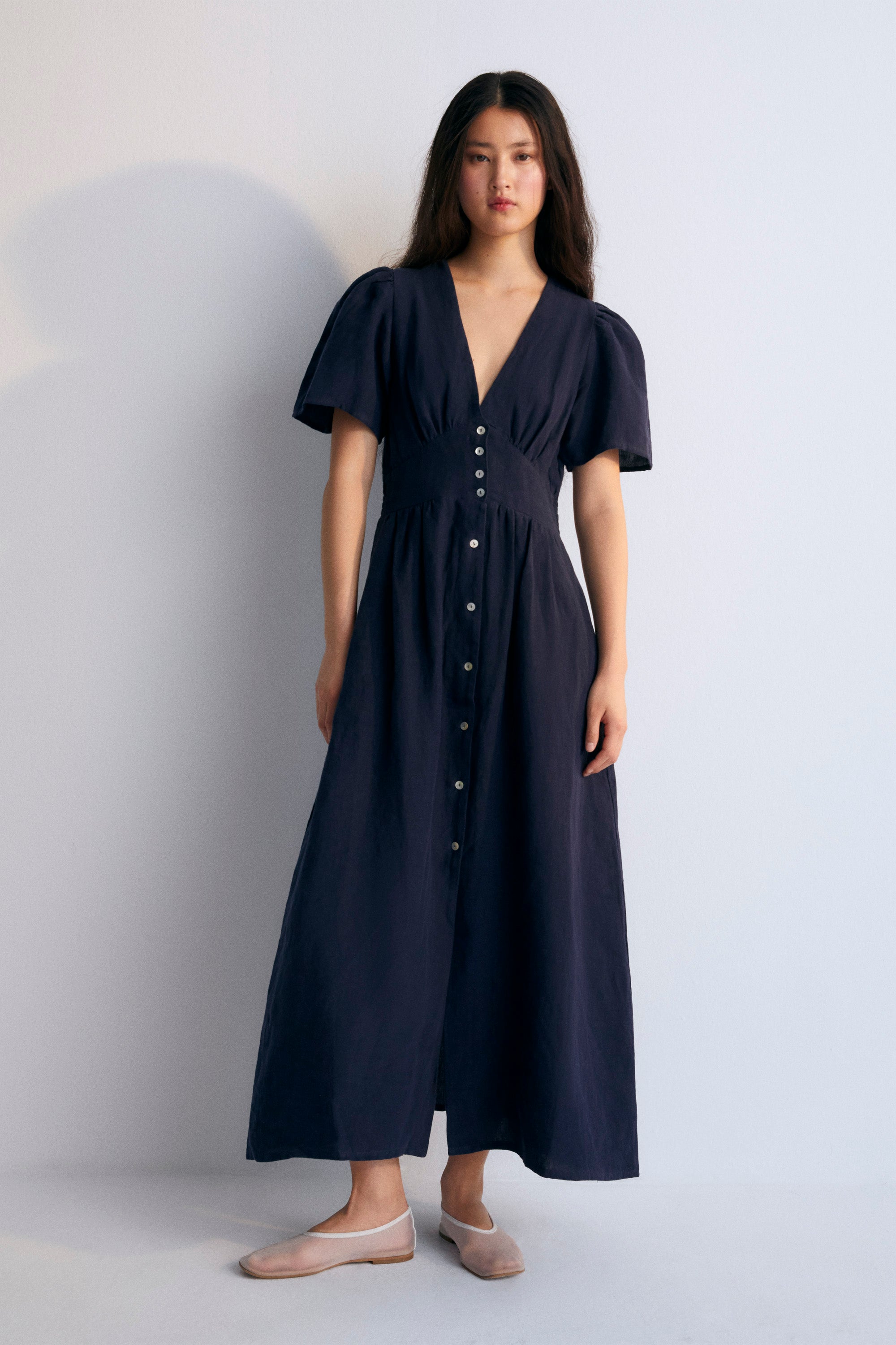 Our bestseller now available in solid colors. Hera Woman Dress 2 in 100% linen, available in three colors: navy, hibiscus, and palm. V-neck, short sleeves with shoulder gathering, and center front buttons.