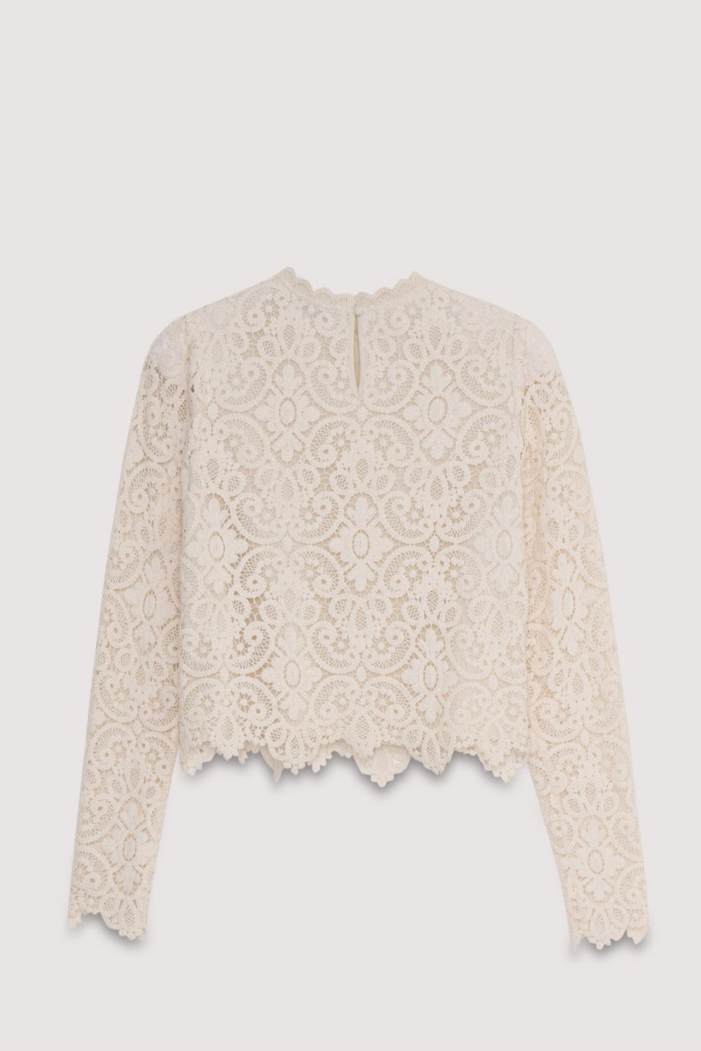 La blouse Lara est une pièce au crochet très spéciale en blanc cassé, dotée de manches ajustées avec un volume subtil au niveau des épaules et d'une ouverture au dos avec fermeture boutonnée.