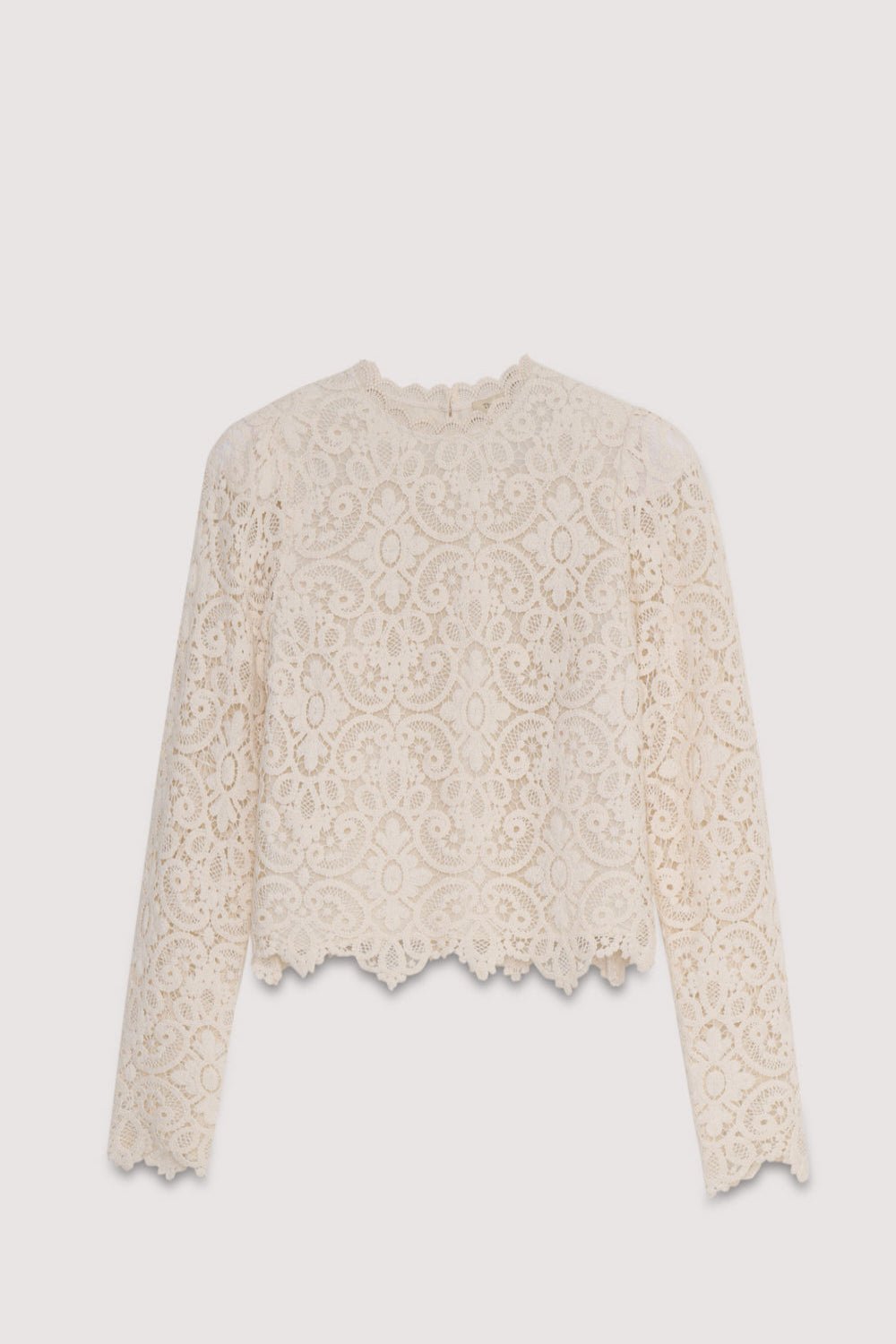 La blouse Lara est une pièce au crochet très spéciale en blanc cassé, dotée de manches ajustées avec un volume subtil au niveau des épaules et d'une ouverture au dos avec fermeture boutonnée.