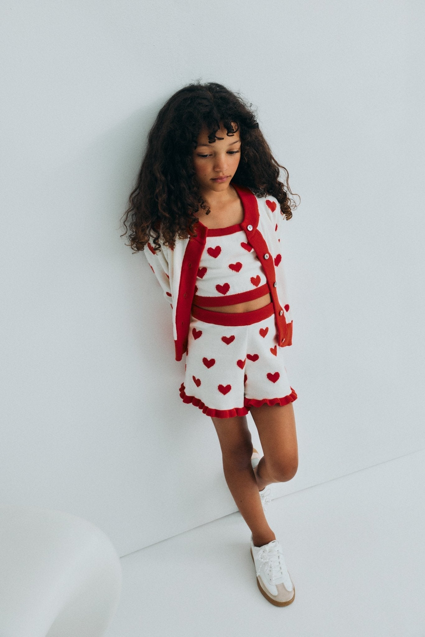 Fine cotton knit shorts featuring a playful heart jacquard, a contrasting ruffle hem, and a comfortable elastic rib waistband for a cute, coordinated summer look.