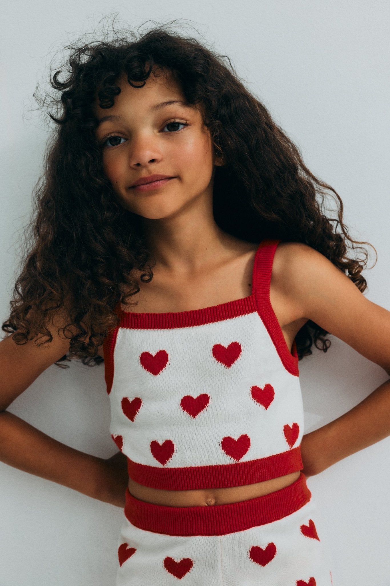 Fine cotton knit shorts featuring a playful heart jacquard, a contrasting ruffle hem, and a comfortable elastic rib waistband for a cute, coordinated summer look.