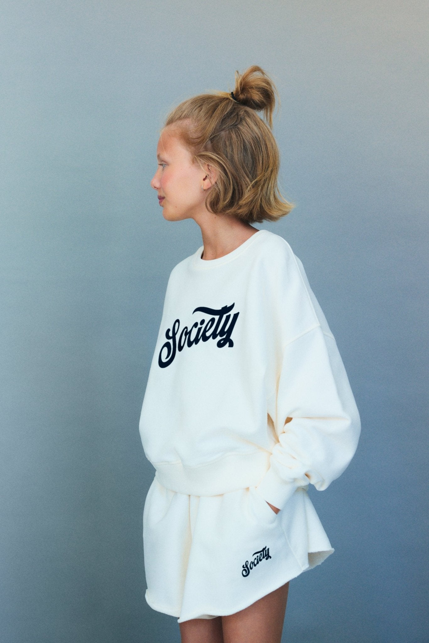 柔らかいコットンフリースを使用したクロップドスウェットシャツ。前面にコントラストのあるグループ刺繍が施され、快適でスタイリッシュなフィット感を実現するリブ仕上げが特徴です。