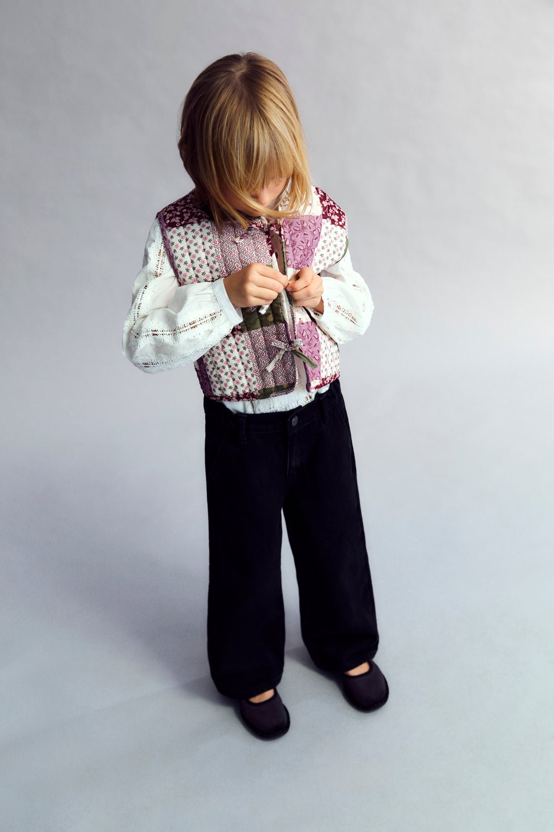 Gilet matelassé en micro-velours côtelé
Doté d'un imprimé patchwork unique, ce gilet a une fermeture sur le devant avec des détails de cravate et de bouton pour une finition charmante