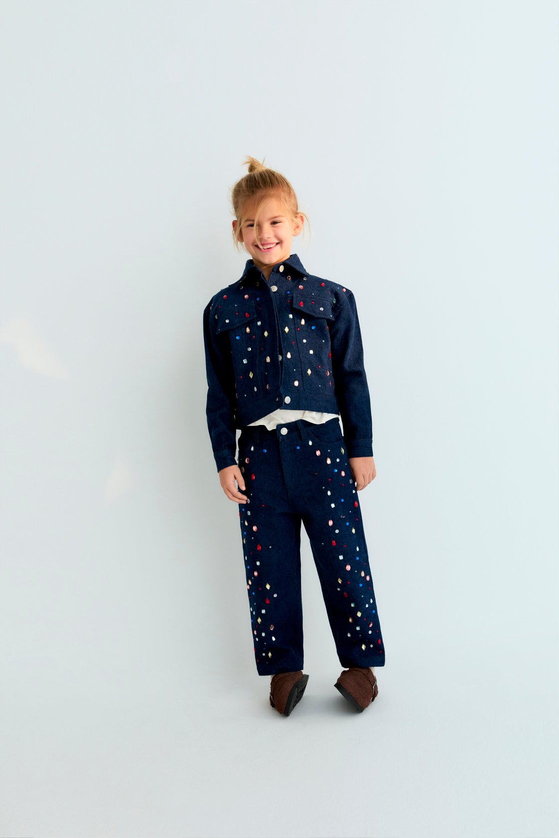 Dark denim jacket with hand-applied multicolored crystal details. TNS embroidery in lurex. Perfect for pairing with the matching pant.