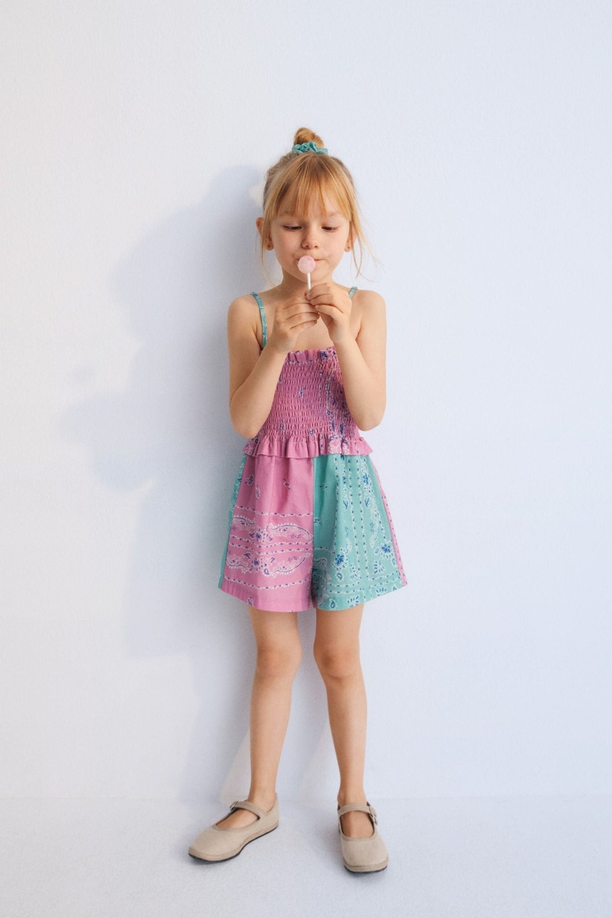 Mileto Jumpsuit in 100% cotton with our hibiscus jade bandana print. The jumpsuit features gathered straps, smocking on the upper part, and shorts combining hibiscus and jade prints. Spring Summer Collection. The New Society.