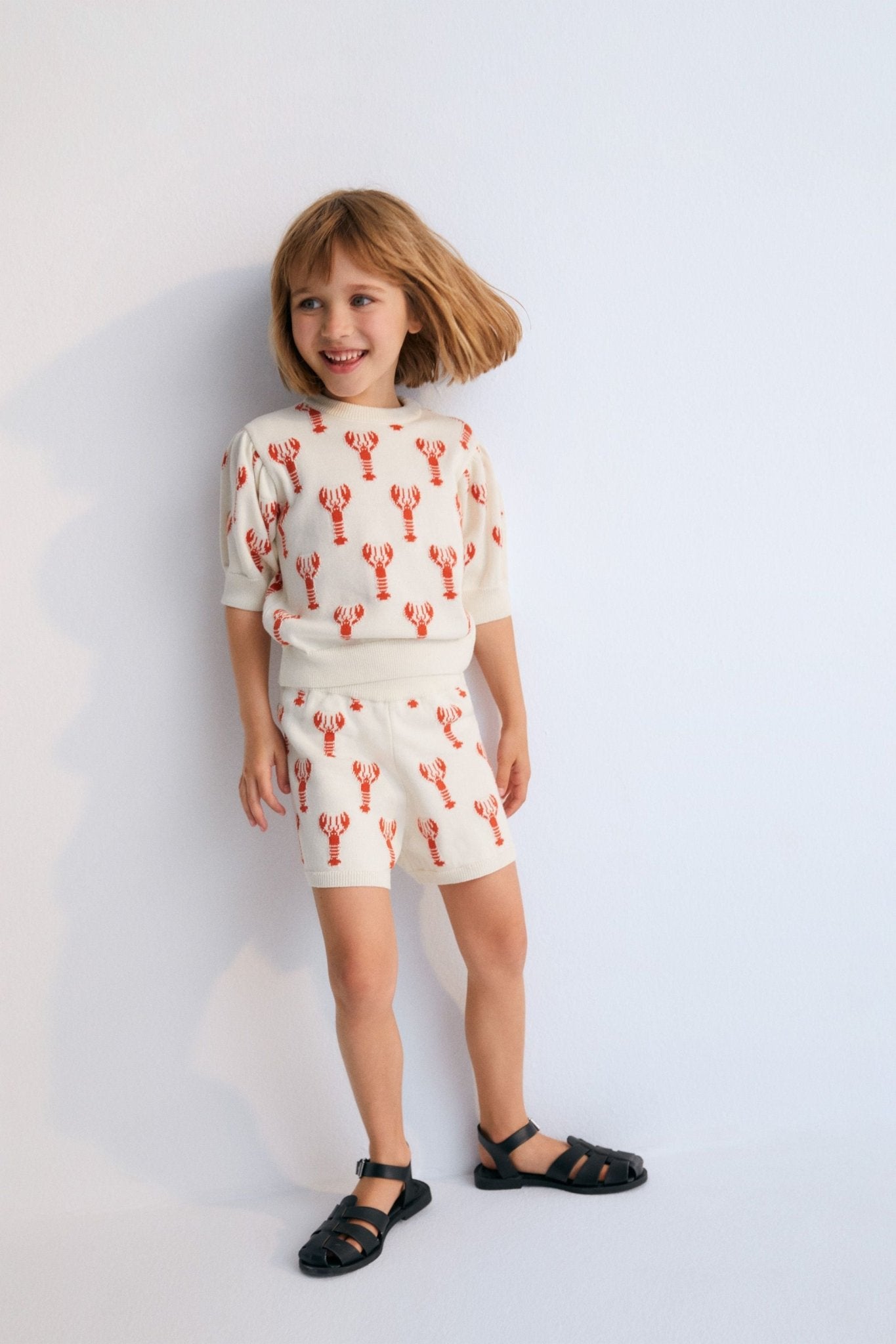 Knit shorts with a playful lobster intarsia pattern and ribbed elastic waistband. It has a matching top to create a perfect summer look. Spring Smmer Collection. The New Society.