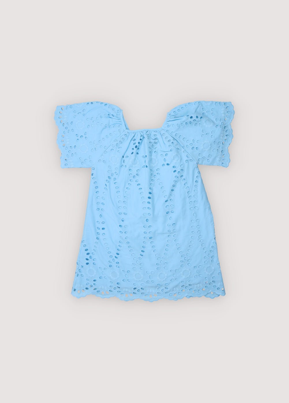 Patmos Dress in embroidered voile fabric, 100% cotton, in powder blue color. The dress features wide sleeves, gathers at the shoulders, front, and back for added volume, with embroidered fabric finishing on the sleeve cuffs and hem. Spring Summer Collection. The New Society.