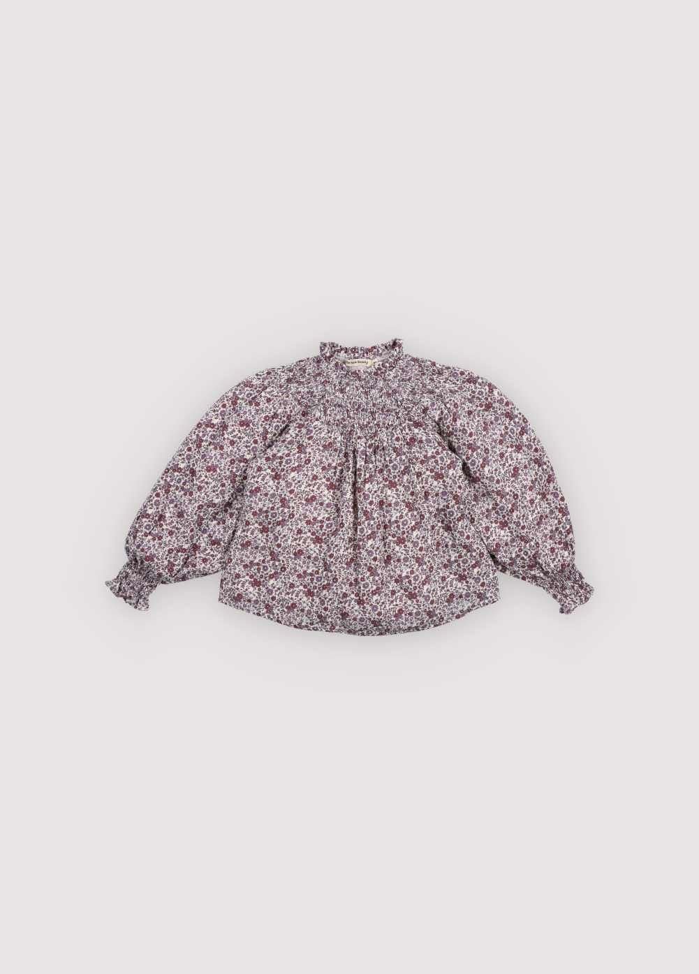 Double gauze blouse with a beautiful floral print, featuring elastic detail at the neckline and a small ruffle trim. Perfect for creating a total look with the matching skirt.