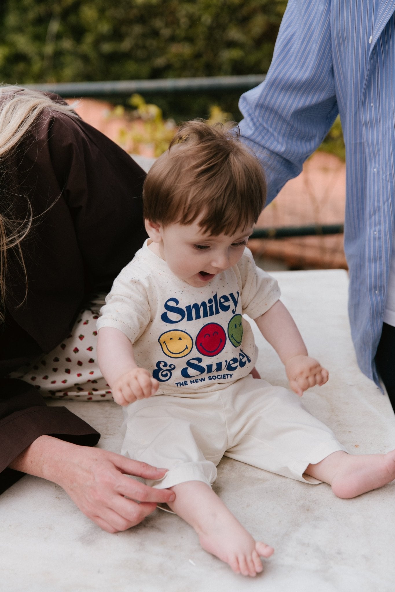 Lustiges, gesprenkeltes Jersey-T-Shirt mit SmileyWorld®-Aufdruck auf der Vorderseite und Druckknöpfen an der Schulter für einfaches Tragen, die einen verspielten, praktischen Touch verleihen.
