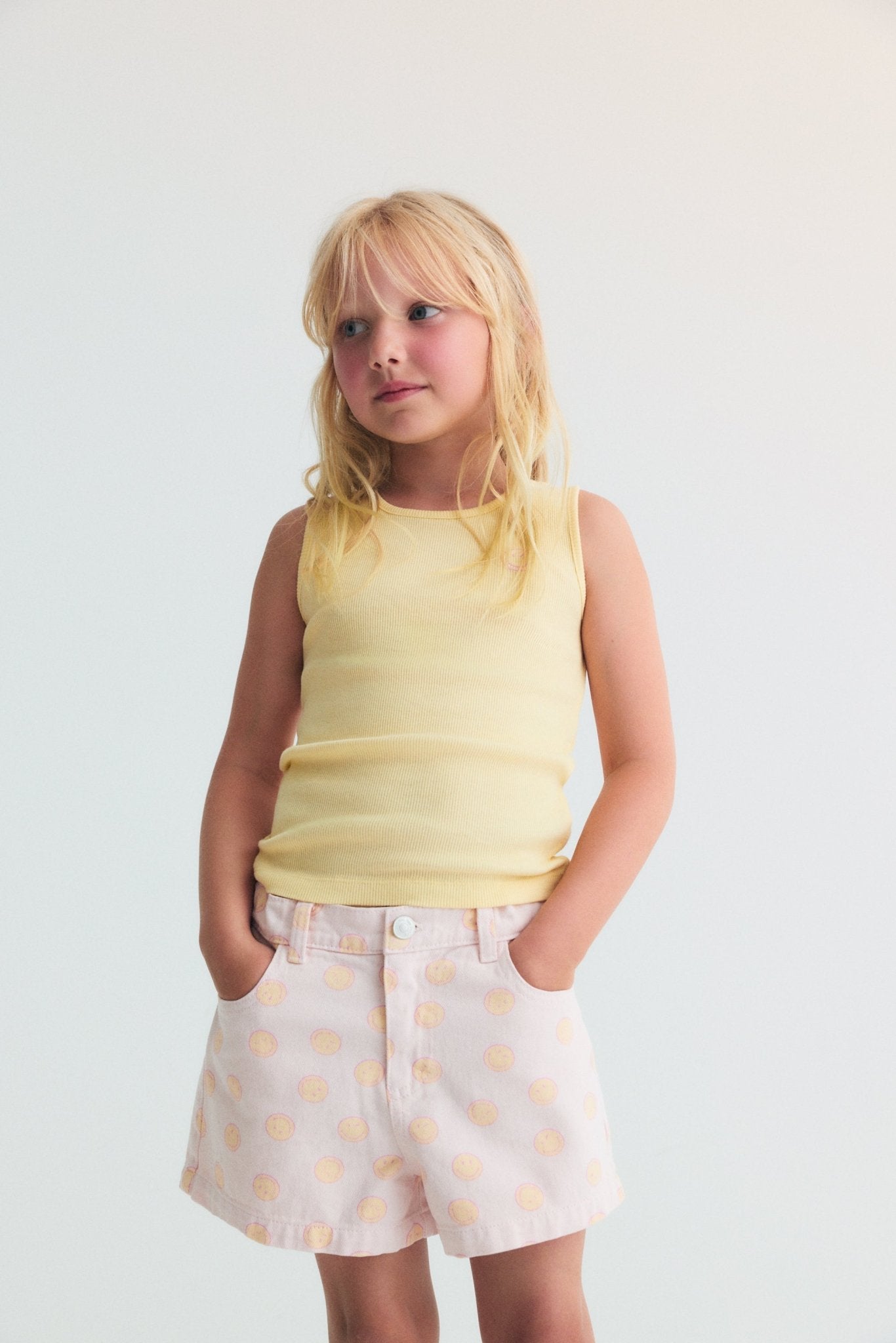 Pantalones cortos de mezclilla en algodón BCI con un divertido estampado SmileyWorld®, una cinturilla elástica ajustable con elástico interior y un parche en el bolsillo trasero para un ajuste divertido y cómodo.