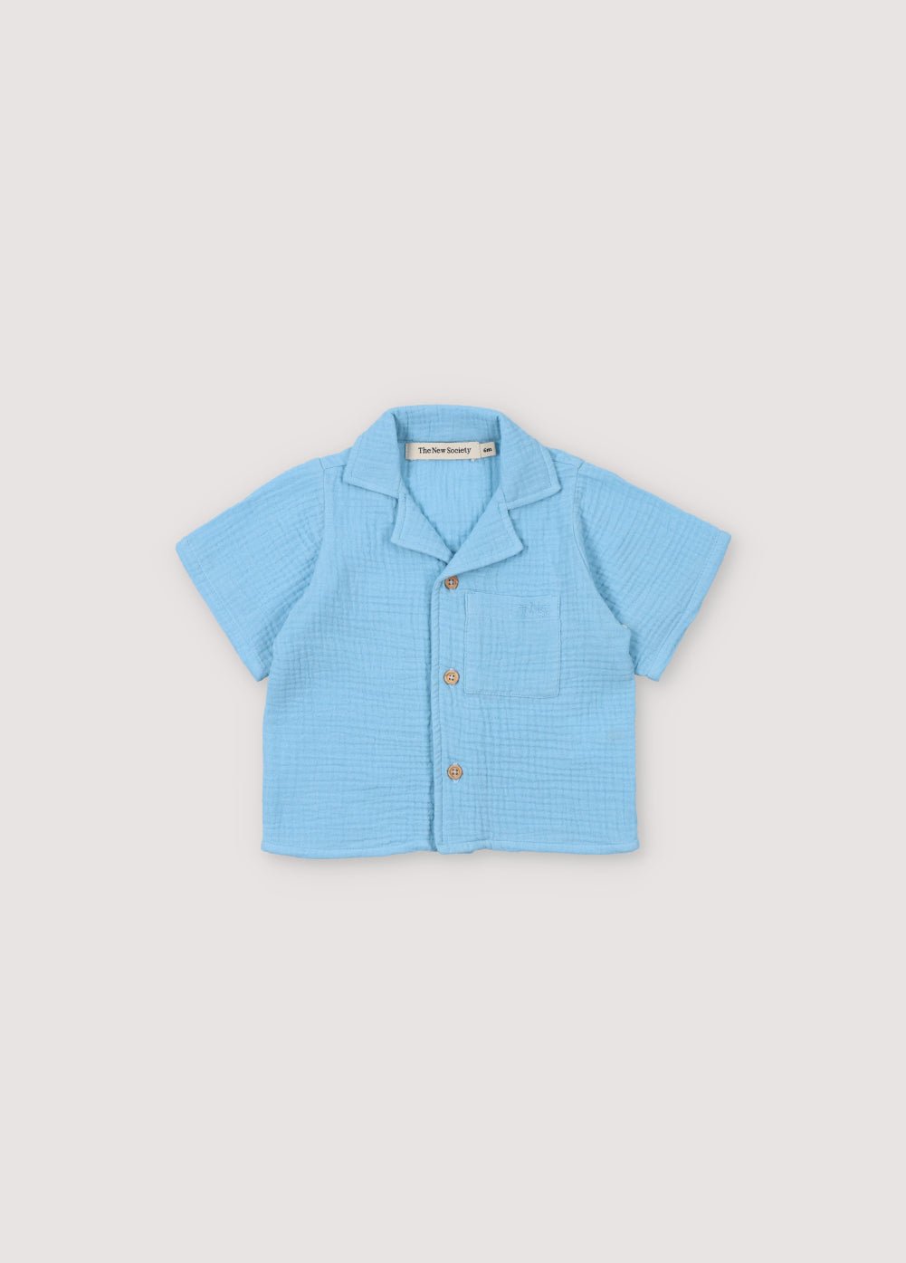 Chemise bébé Spyros en tissu mousseline 100% coton dans notre coloris bleu poudré. Broderie TNS Kids assortie. Collection Printemps Été. The New Society. Collection Printemps Été. The New Society.