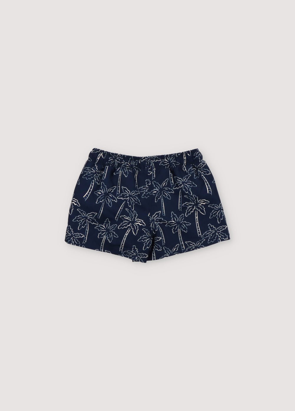 Maillot de bain à imprimé palmiers contrasté sur fond bleu marine, doté d'une taille élastique avec cordon de serrage réglable. Collection Printemps Été. The New Society.