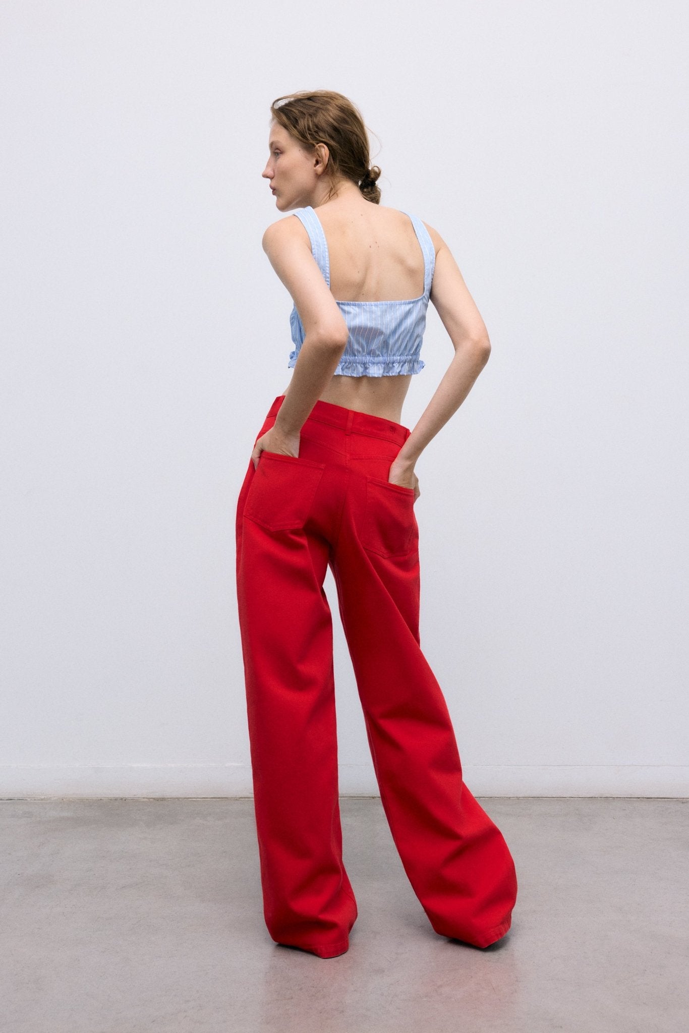 Notre pantalon large classique confectionné en denim doux 100 % coton, maintenant disponible dans une belle teinte rouge qui ajoute du caractère et du style à n'importe quelle tenue.