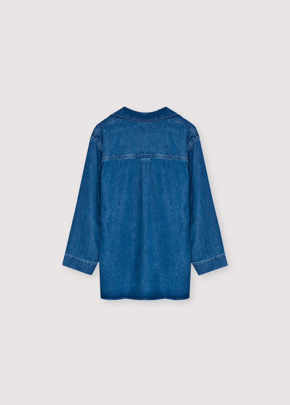 Crafted from 100% Tencel for a soft, lightweight feel, this polo-style shirt features an oversized fit and a front opening with hidden buttons.