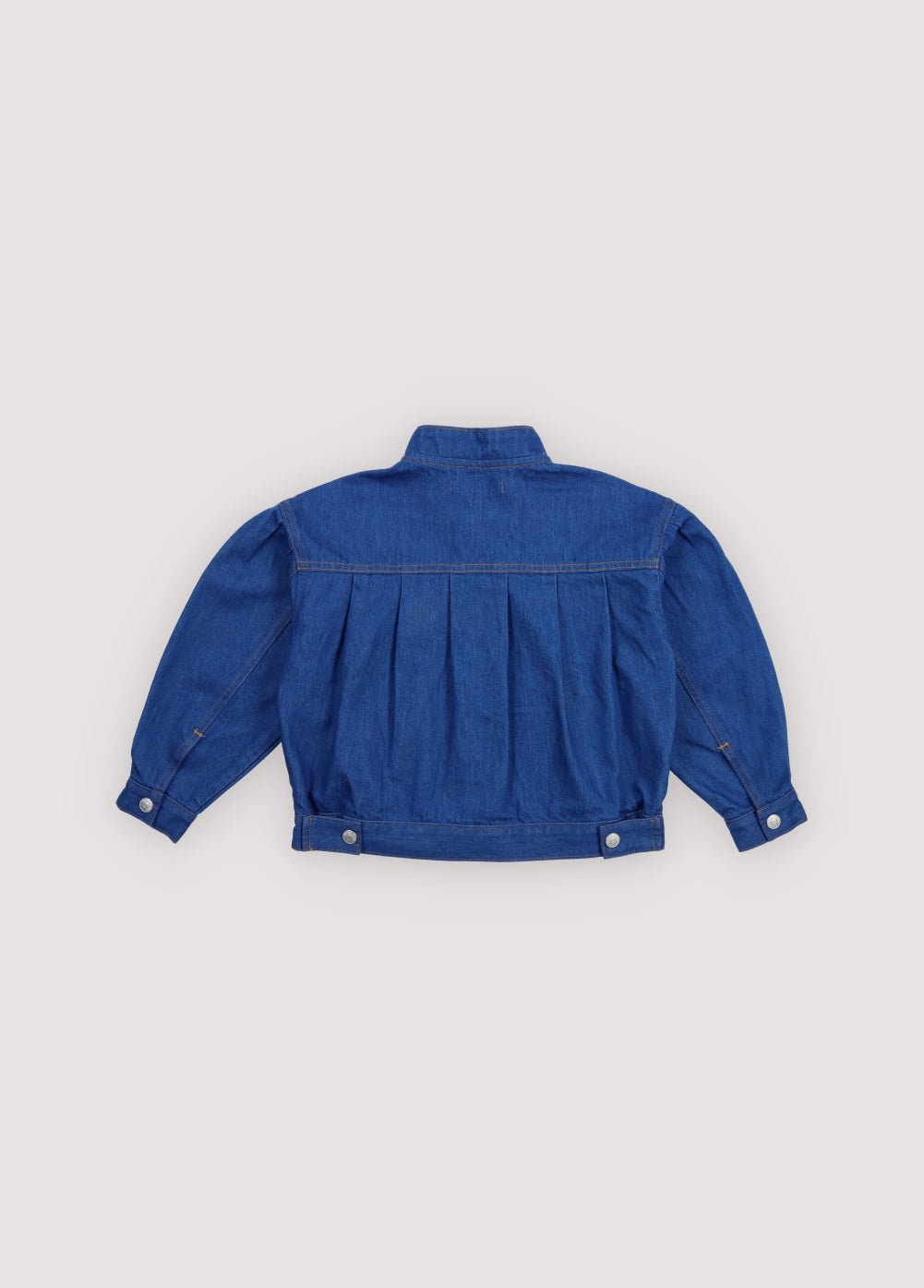 Chaqueta vaquera con detalles de pliegues en la parte delantera y trasera, canesú y bolsillos, creando una silueta estructurada pero relajada.