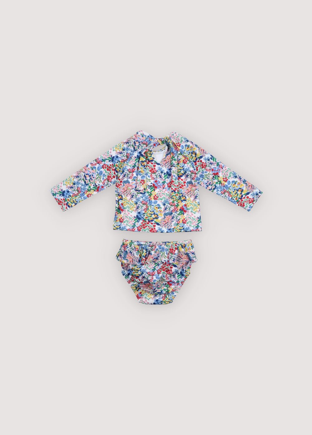 Two piece long sleeve swimsuit featuring a beautiful floral print, a back cutout, and a tie closure for a secure and stylish fit.