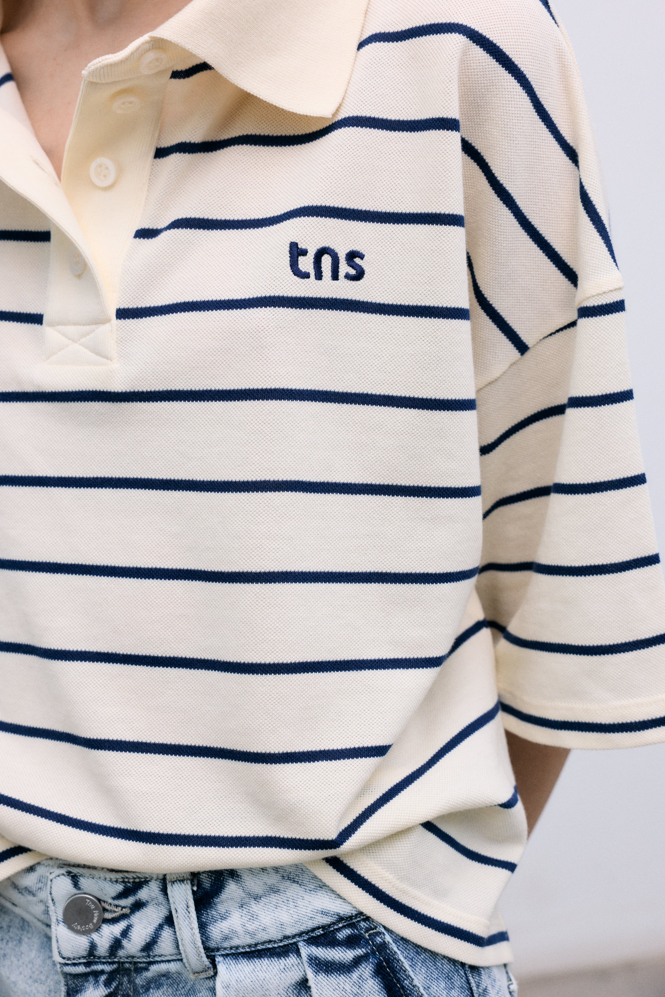 Cropped polo crafted in soft piqué fabric, featuring contrasting stripes and a structured twill collar.