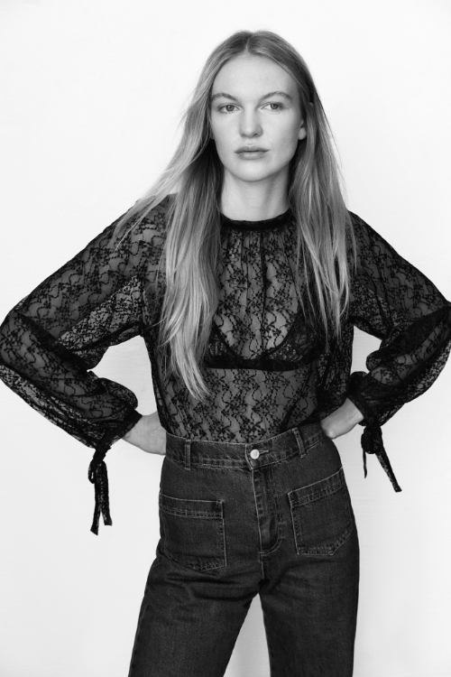 Crafted from a delicate, special lace fabric, this black blouse exudes timeless elegance.