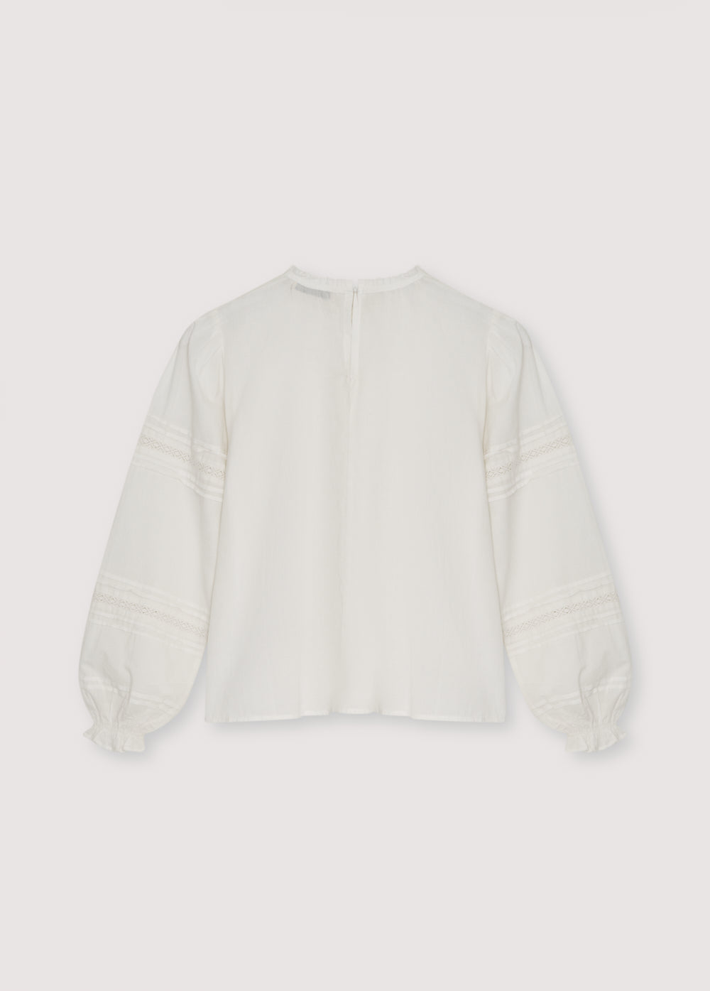 Romantic-style blouse with a front yoke detail in lace and a ruffle finish, along with lace details on the sleeves. It features a round neckline with a small ruffle trim and a back opening with a button closure.