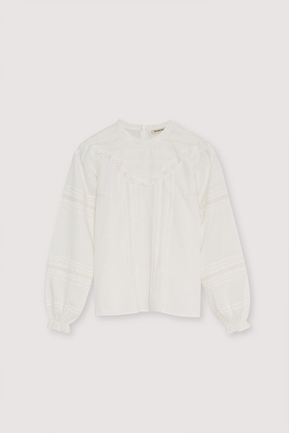 Romantic-style blouse with a front yoke detail in lace and a ruffle finish, along with lace details on the sleeves. It features a round neckline with a small ruffle trim and a back opening with a button closure.