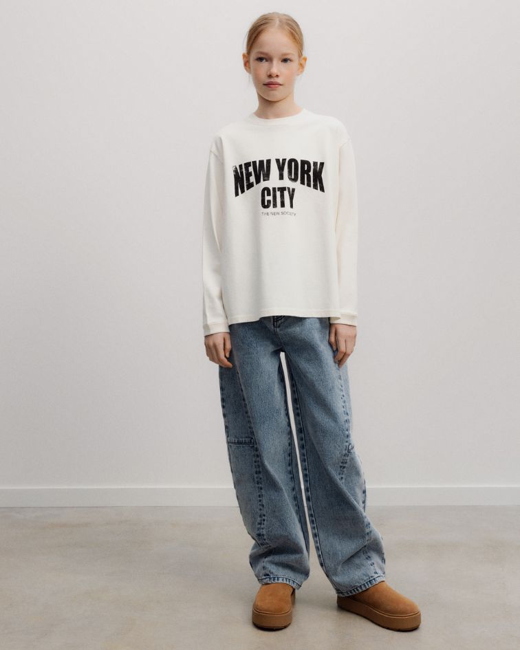 The TNS Denim Teen Curved Trouser explores contemporary denim through a sculptural curved silhouette, where considered pattern cutting creates effortless volume and movement.