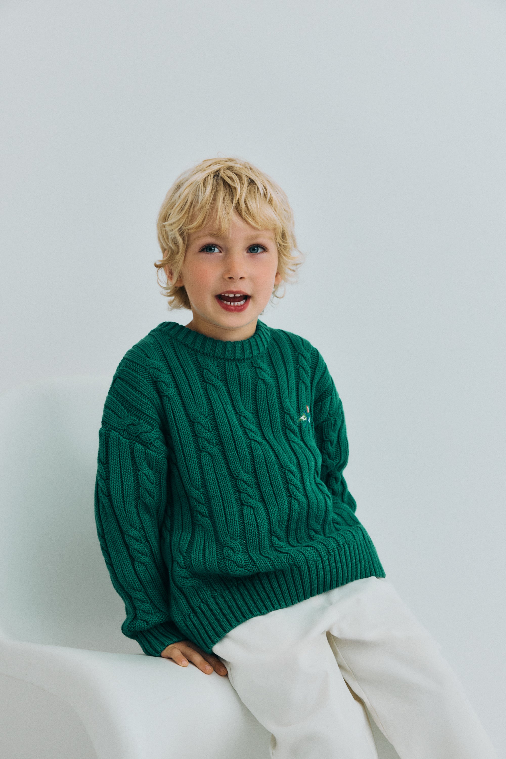 Cable knit sweater with&nbsp;ribbed trims and a playful branded embroidery featuring a flag motif for a subtle, stylish detail.