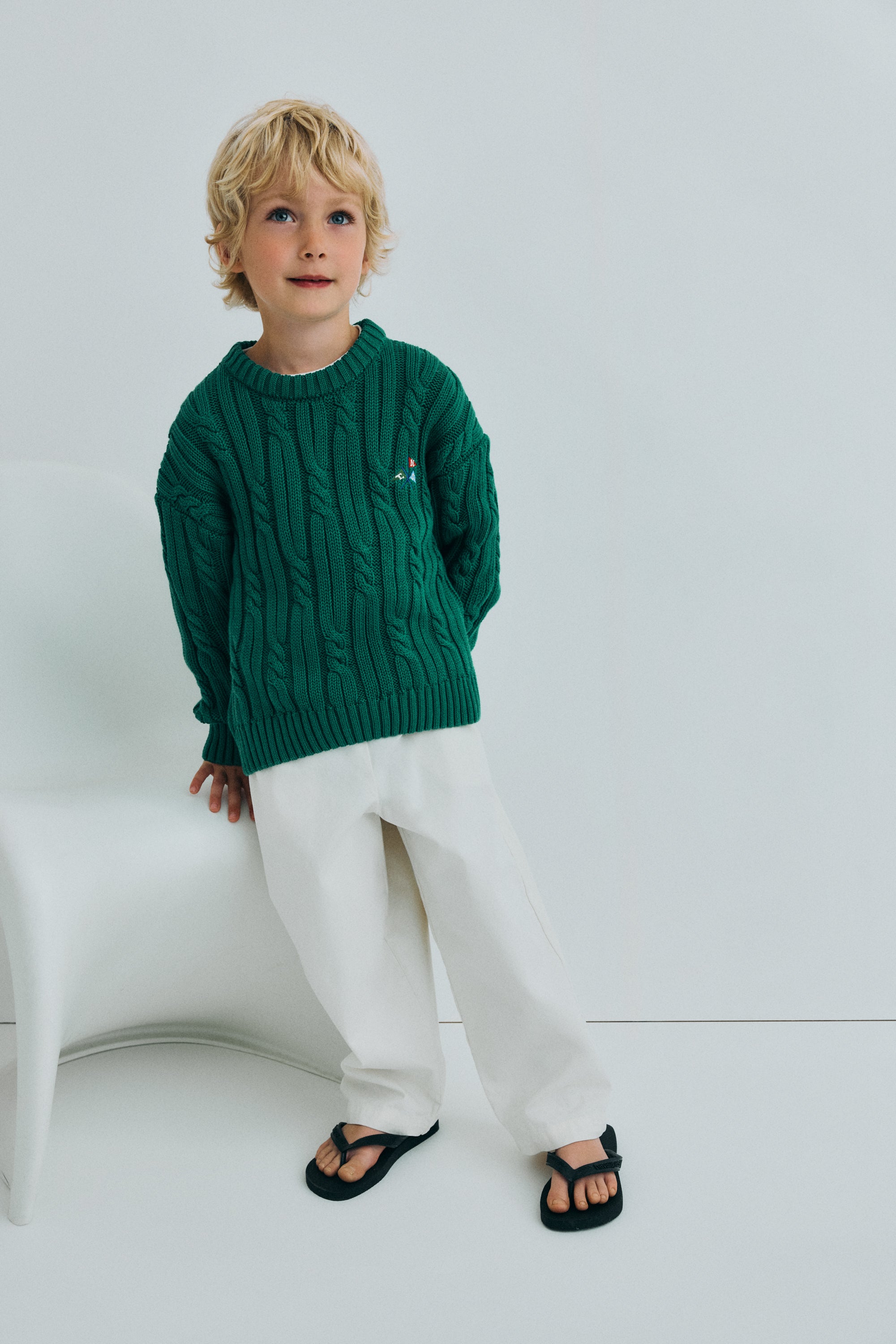 Cable knit sweater with&nbsp;ribbed trims and a playful branded embroidery featuring a flag motif for a subtle, stylish detail.
