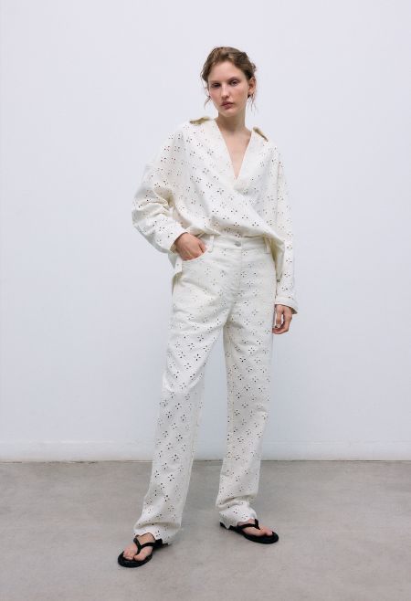 Polo-style blouse with a shirt collar and front opening, crafted from a delicate and special denim fabric featuring all-over embroidery for a unique textured finish.